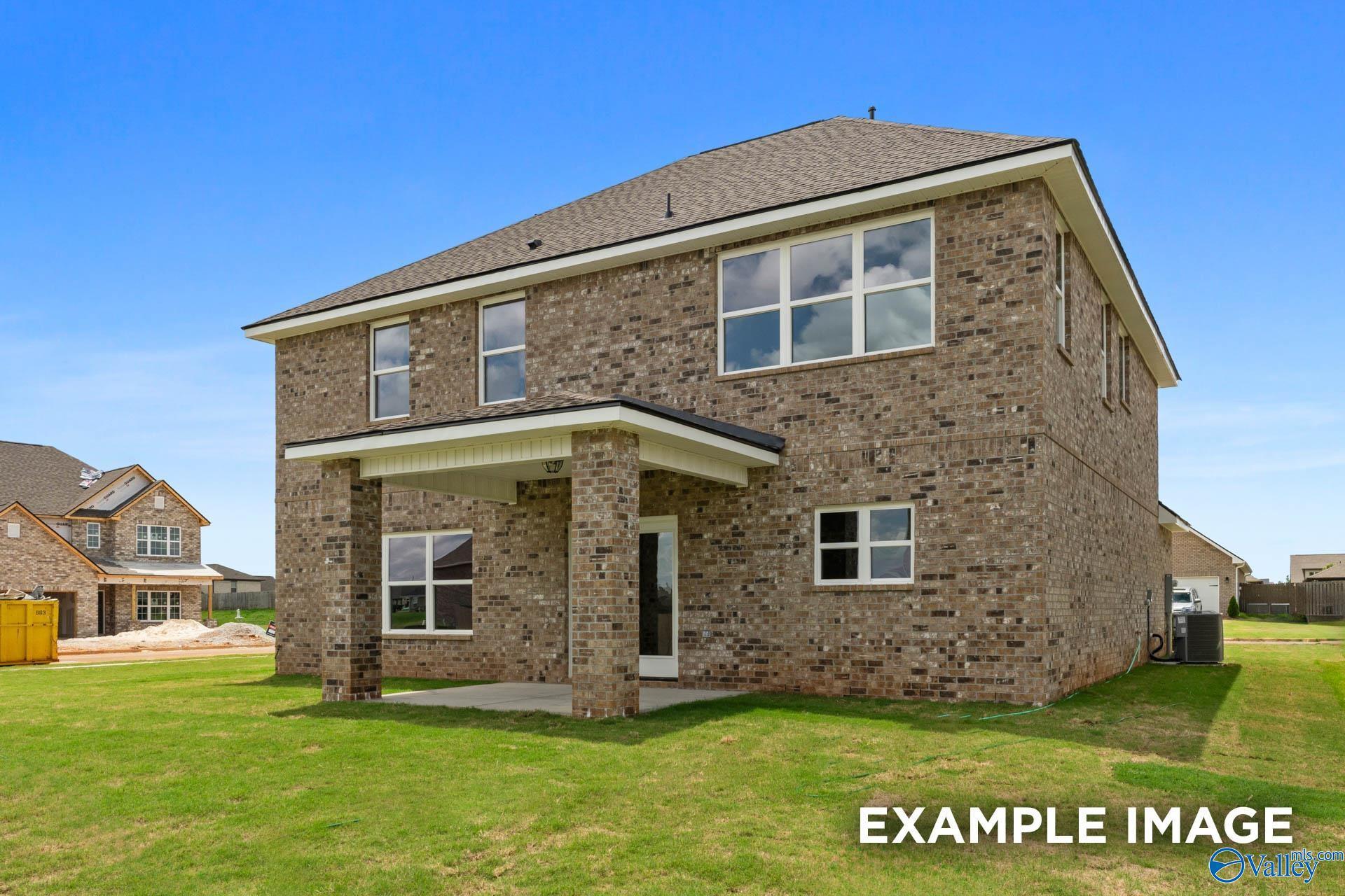 Two-story brick home with covered front porch, large windows, and green lawn in Ivy Hills, Toney, Alabama by Davidson Homes