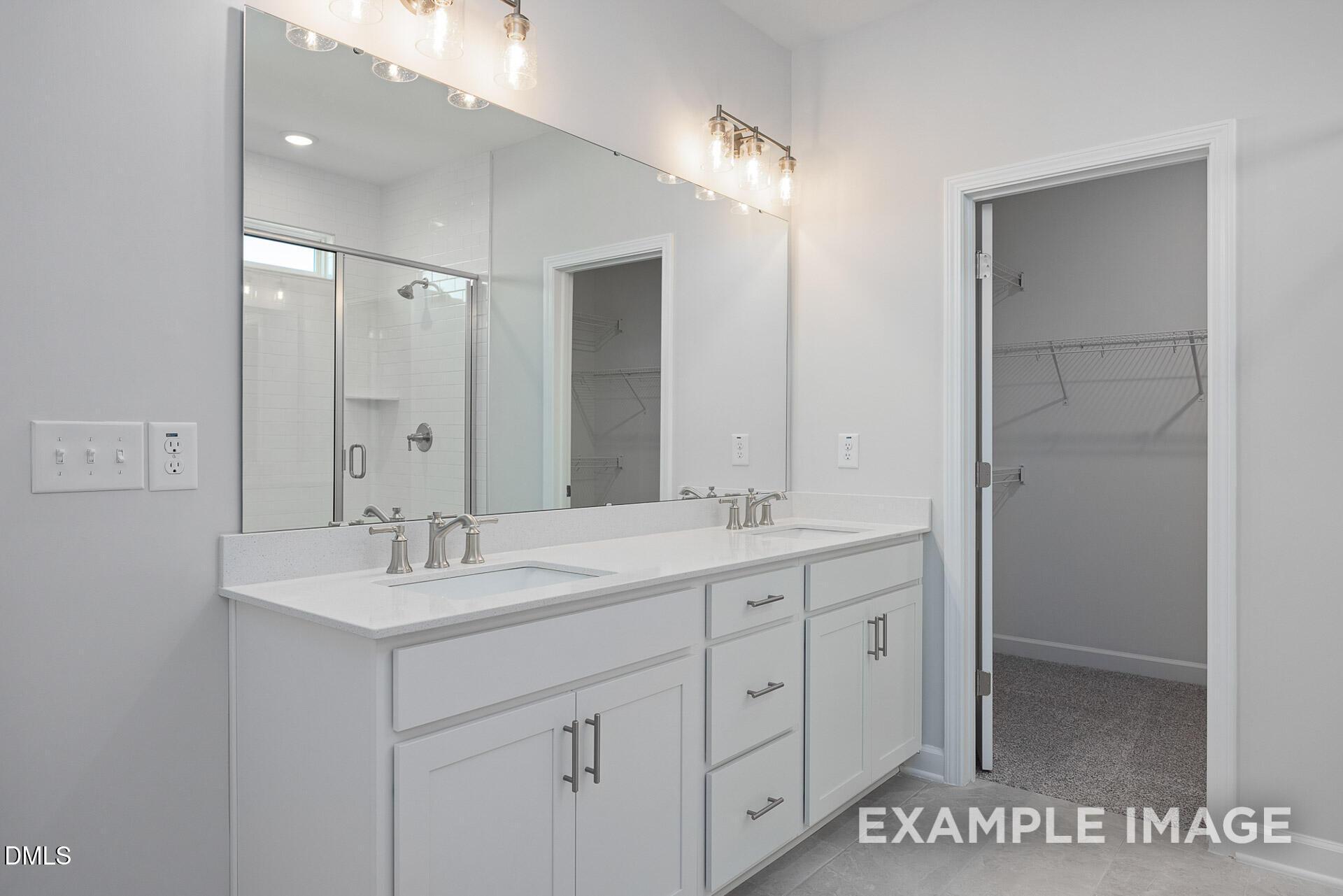 Double vanity bathroom with walk-in closet in The Magnolia A floor plan at Retreat at North Main, Lillington, NC.