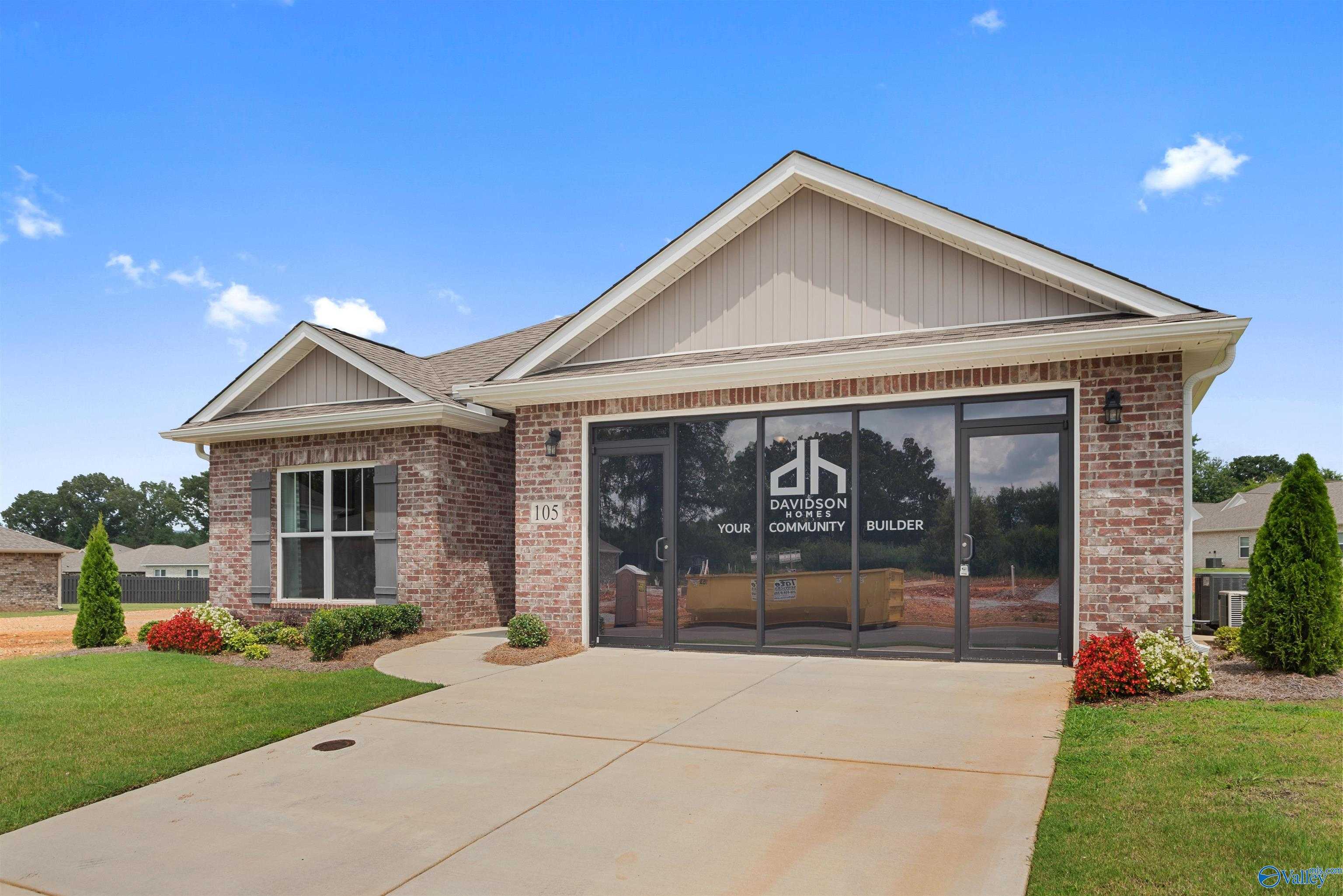 Modern single-story home exterior with brick facade, 2-car garage, and Davidson Homes signage in Flint Meadows, New Market, Alabama