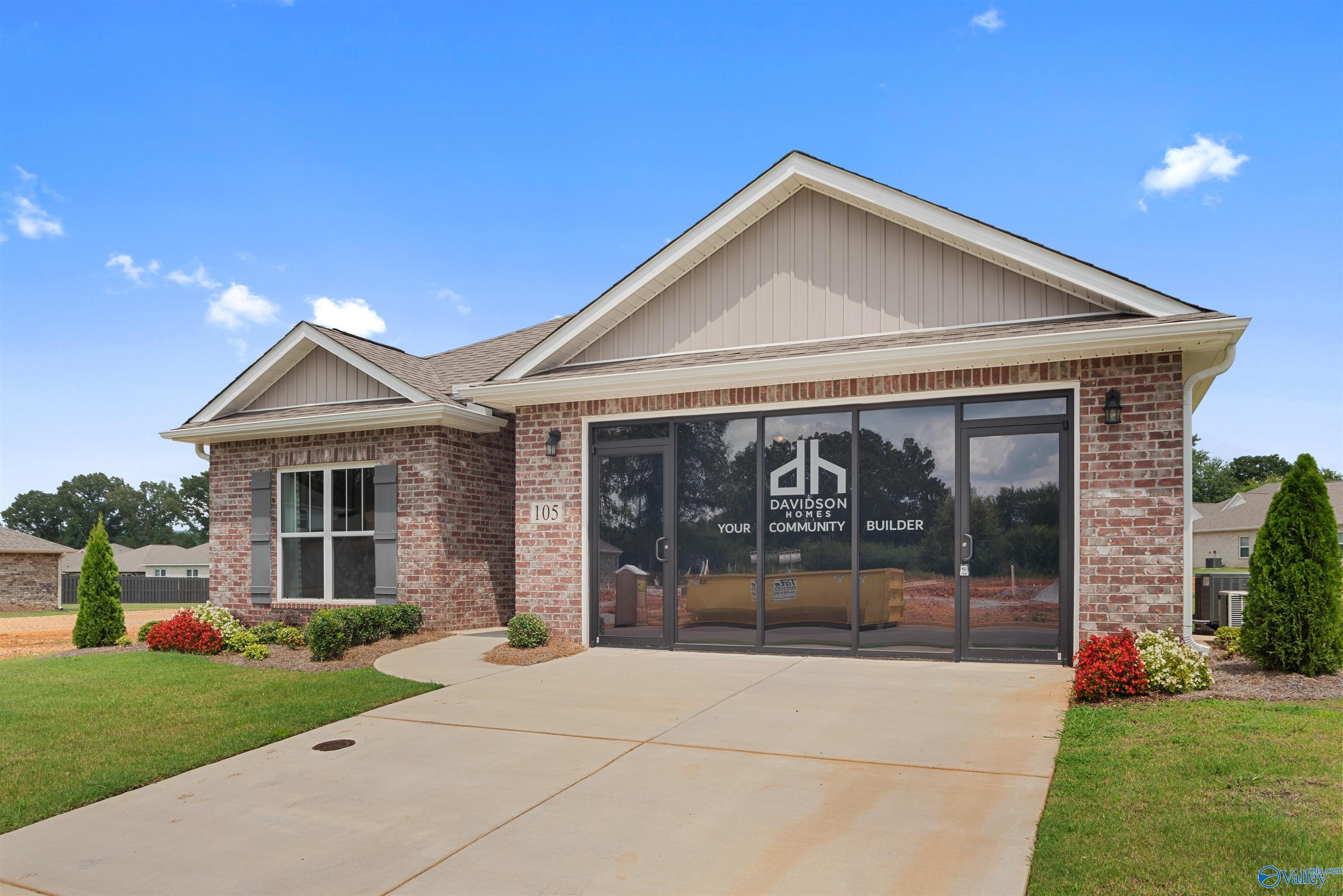 Modern single-story home exterior with brick facade, 2-car garage, and Davidson Homes signage in Flint Meadows, New Market, Alabama