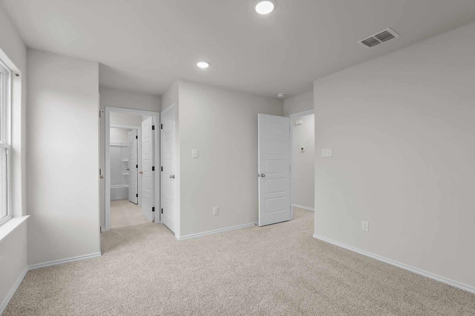 Spacious bedroom in The Sequoia C floor plan featuring neutral carpet, recessed lighting, and an en-suite bathroom entrance.