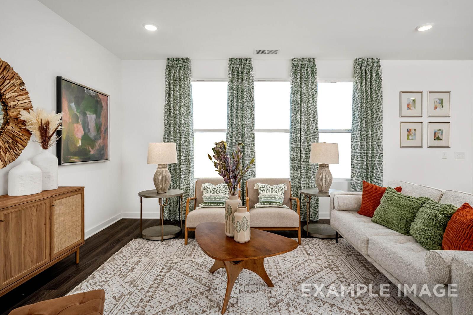 Cozy living room in The Gordon C home design with beige sofa, armchairs, wooden coffee table, large windows, and green curtains