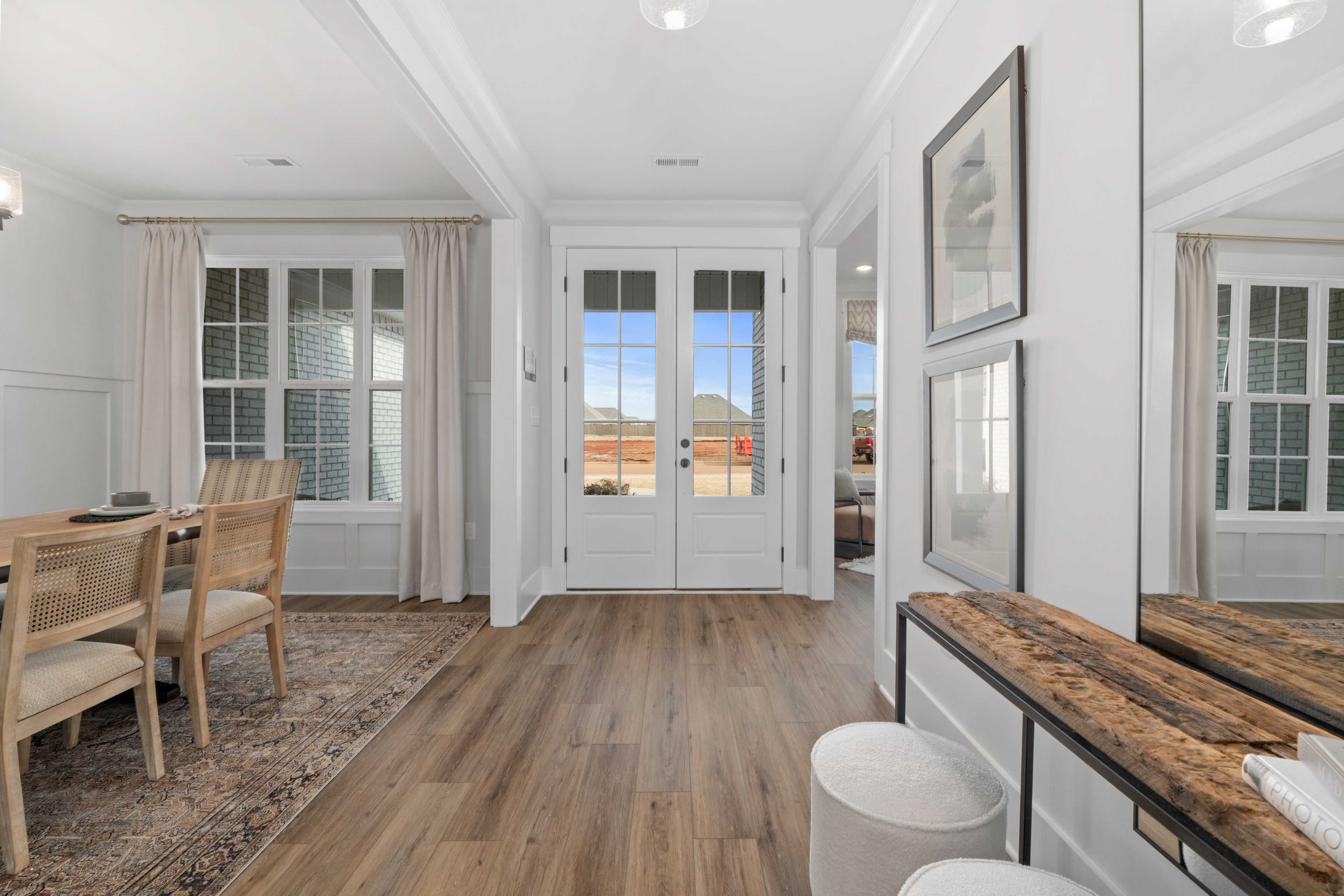 Spacious dining room with French doors, rattan chairs, and hardwood floors at Briercreek in Meridianville, Alabama