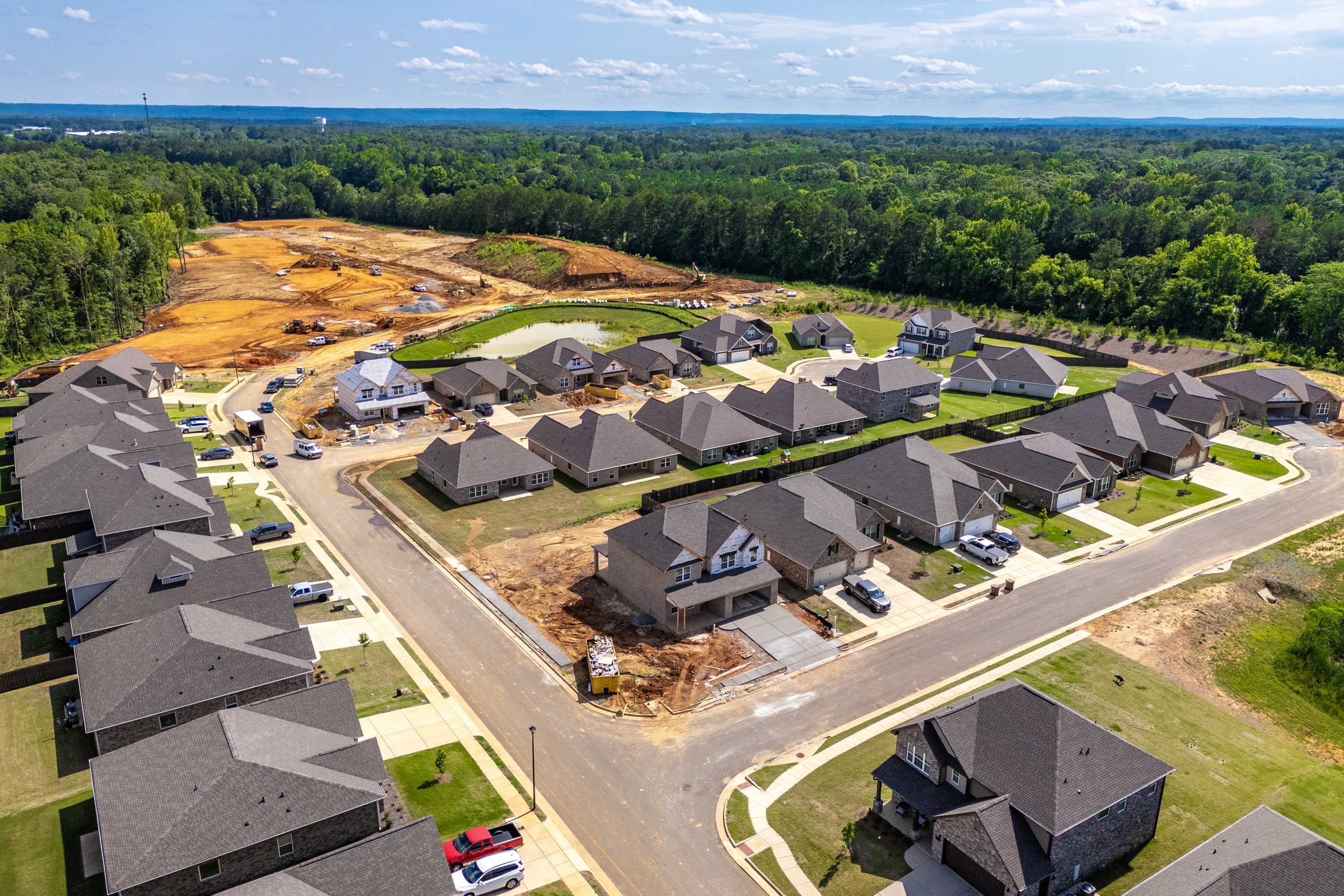 Aerial view of new homes under construction in Cain Park Hartselle Alabama by Davidson Homes amid lush green forests
