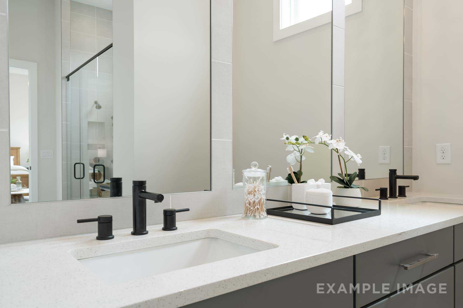 Modern bathroom vanity with black matte faucets, white quartz countertop, orchids at Manor Estates in Marietta GA by Davidson Homes
