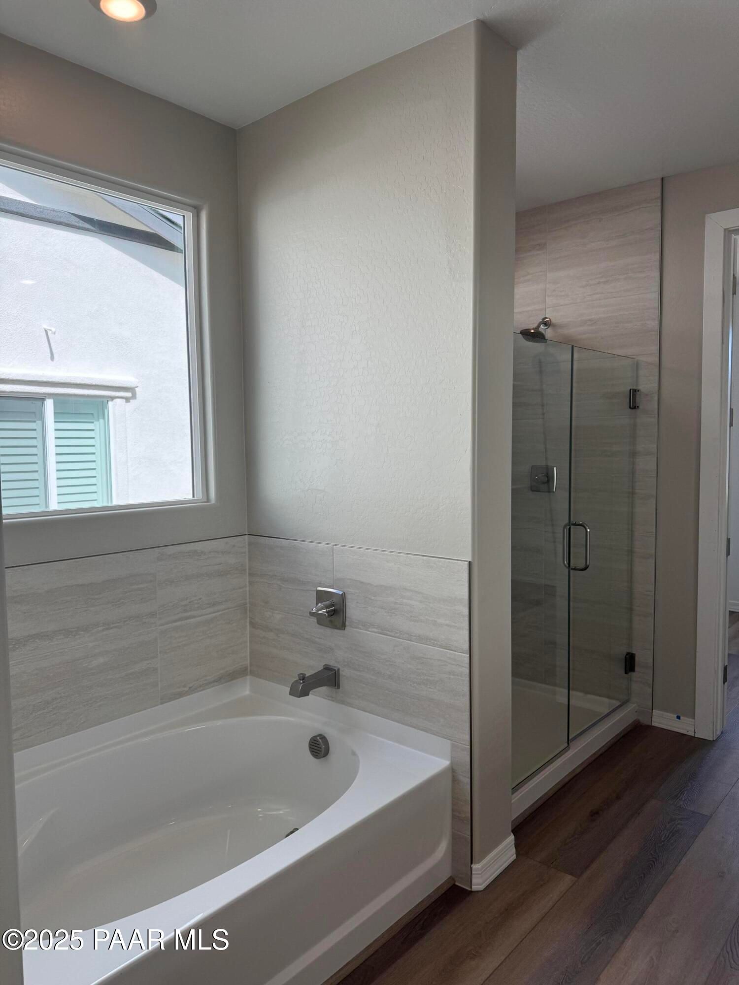Elegant master bathroom featuring deep soaking tub, glass-enclosed walk-in shower, and shiplap walls in Davidson Homes The Monarch A, Prescott, AZ