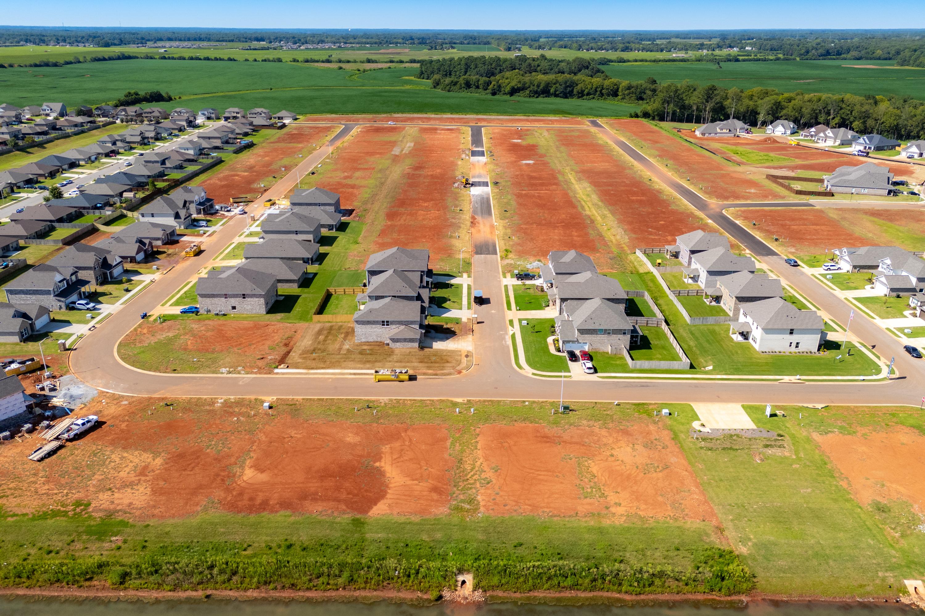 Aerial view of Walker's Hill neighborhood in Meridianville AL with new Davidson Homes, red clay lots, and surrounding farmlands