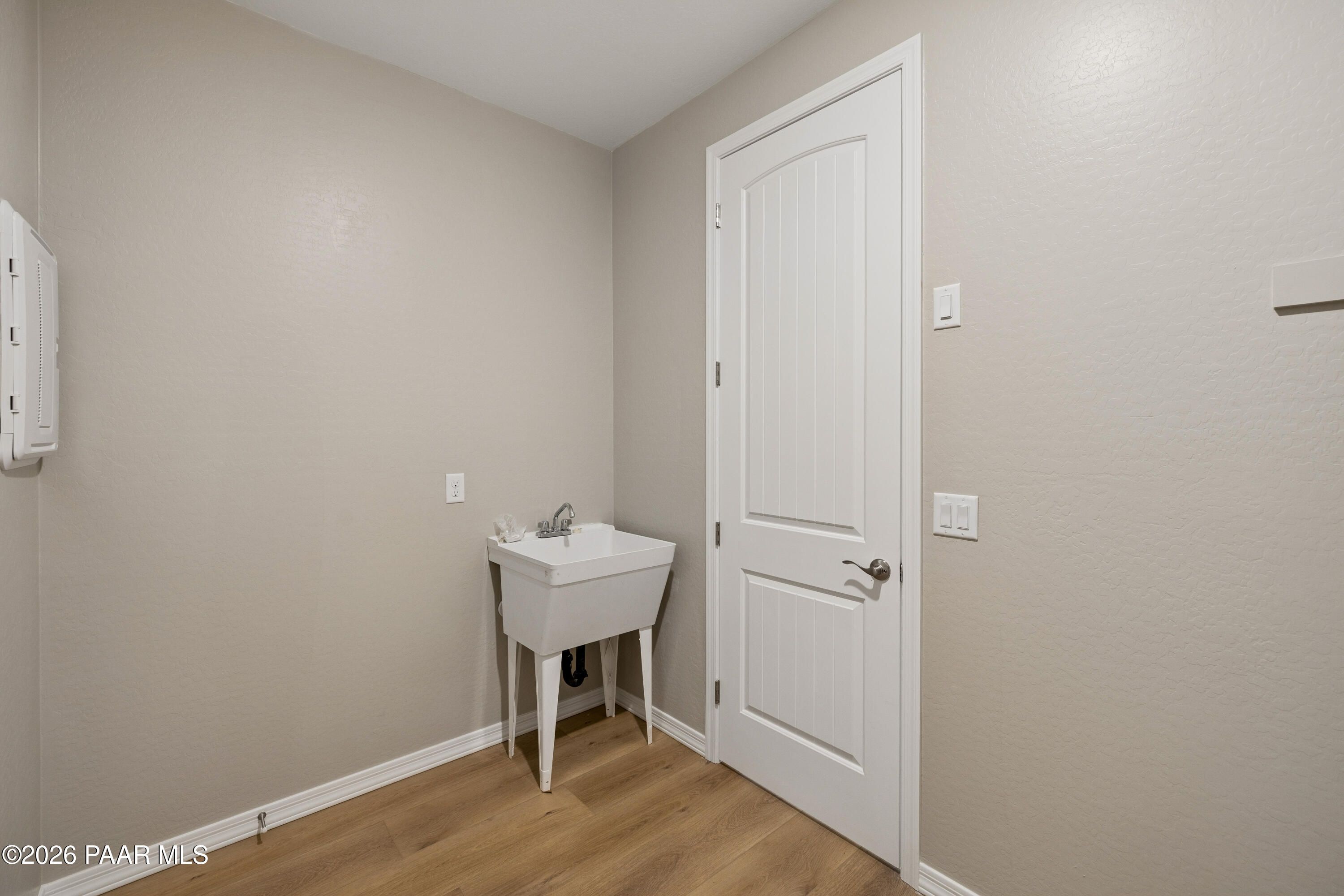 Functional laundry room featuring utility sink, wall cabinet, and beige walls in Davidson Homes The Harmony A, Prescott Valley, AZ