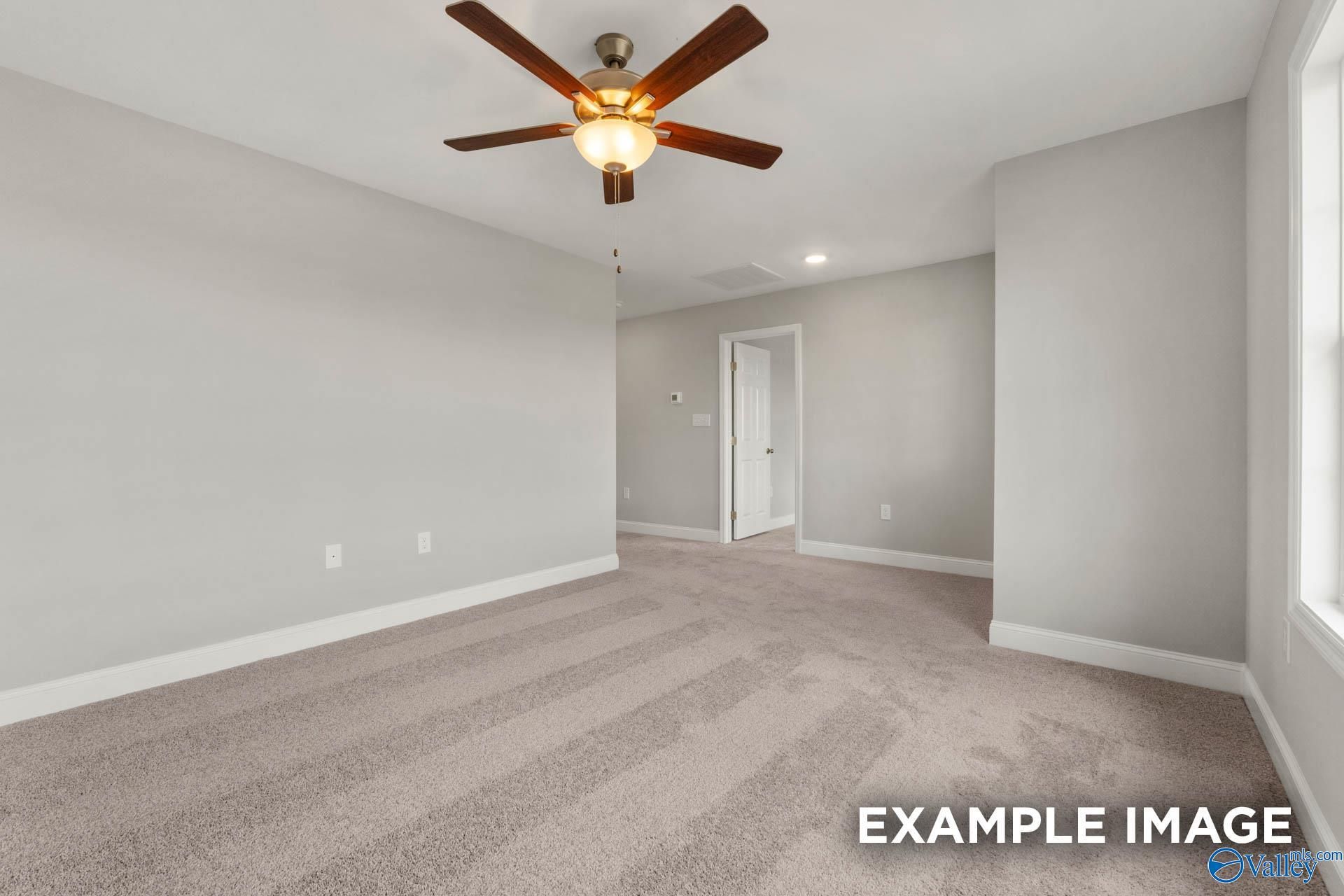 Spacious empty bedroom with ceiling fan, gray walls, beige carpet in Davidson Homes The Shelby B, Athens, Alabama