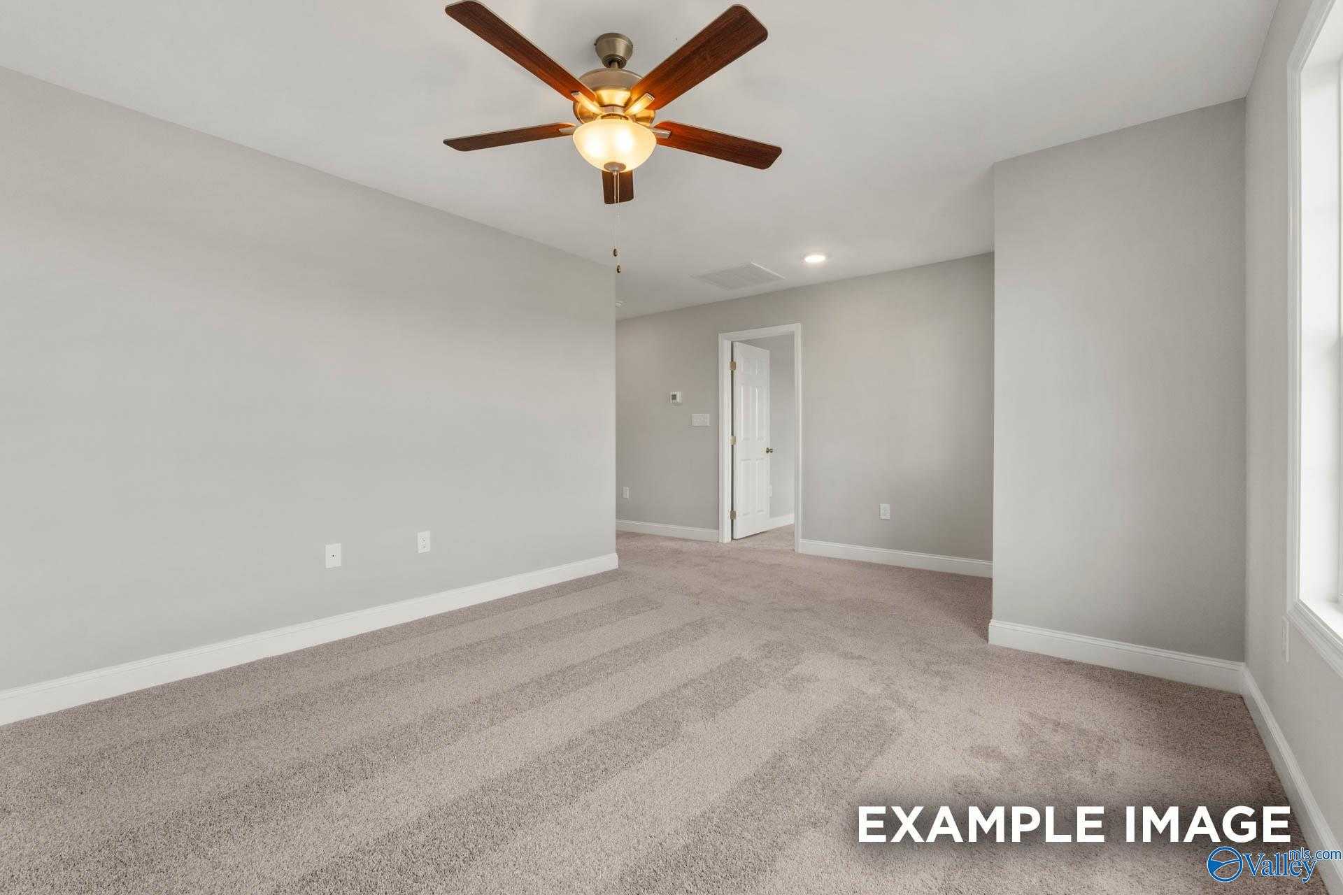 Spacious empty bedroom with ceiling fan, gray walls, beige carpet in Davidson Homes The Shelby B, Athens, Alabama