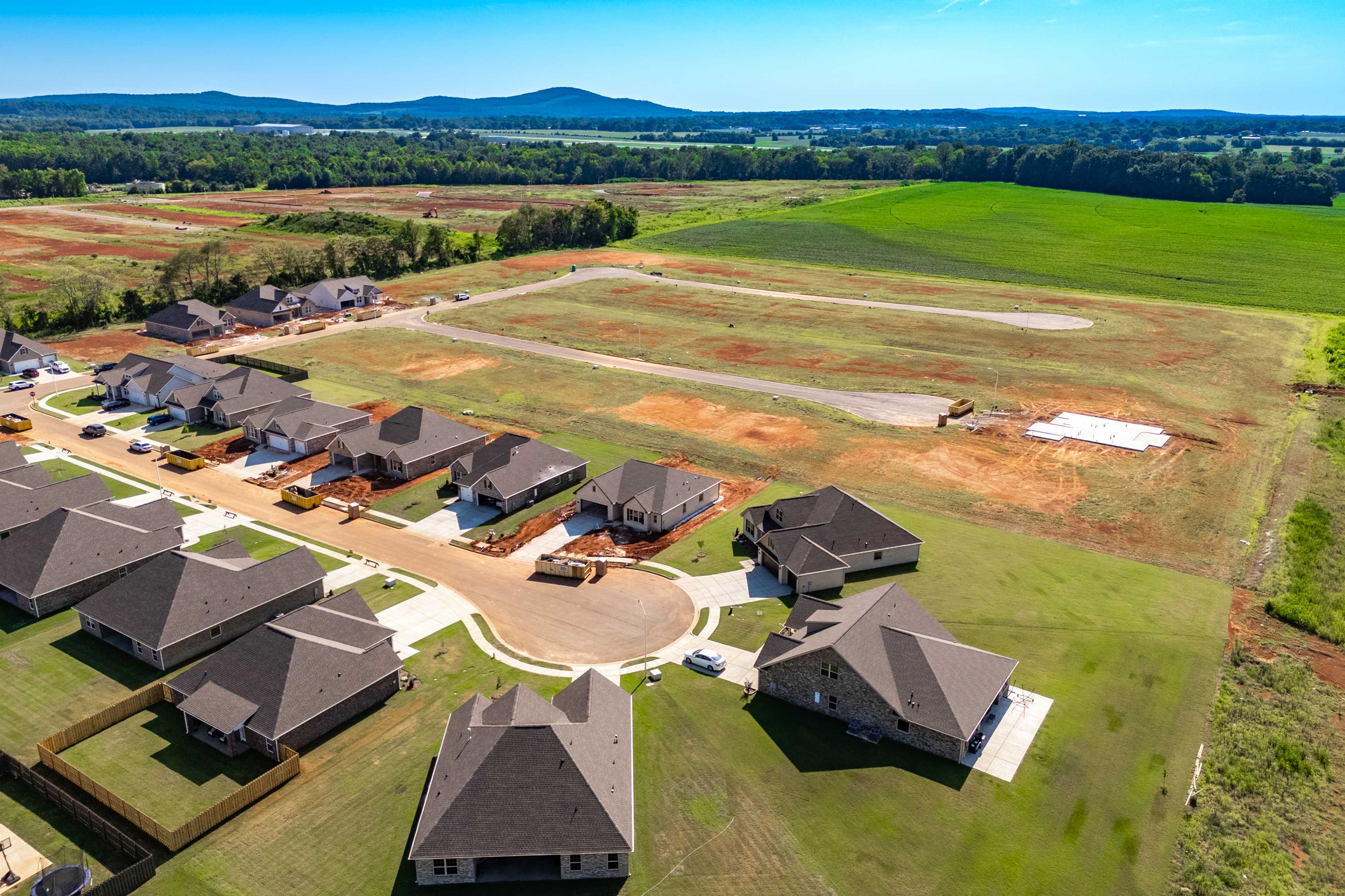 Aerial view of Pikes Ridge neighborhood in Meridianville Alabama featuring new Davidson Homes construction amid green fields and hills