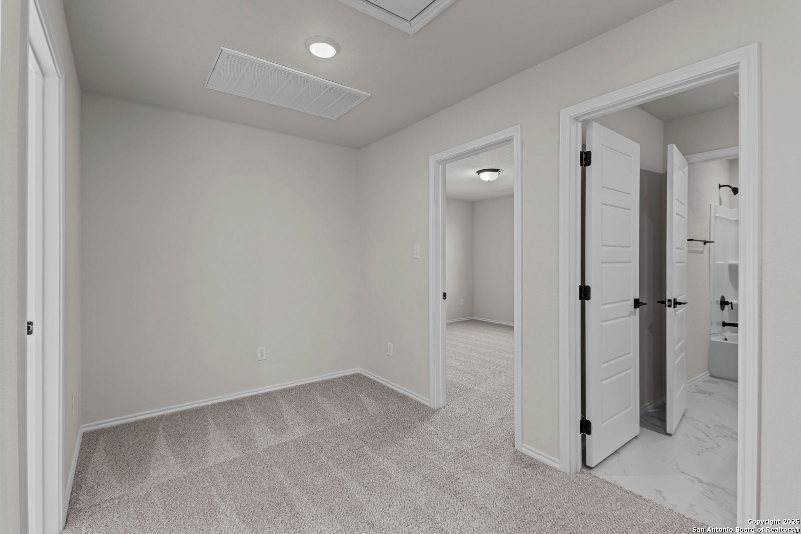 Spacious secondary bedroom with open en-suite bathroom door in Davidson Homes The Douglas C, Hannah Heights, Seguin, Texas