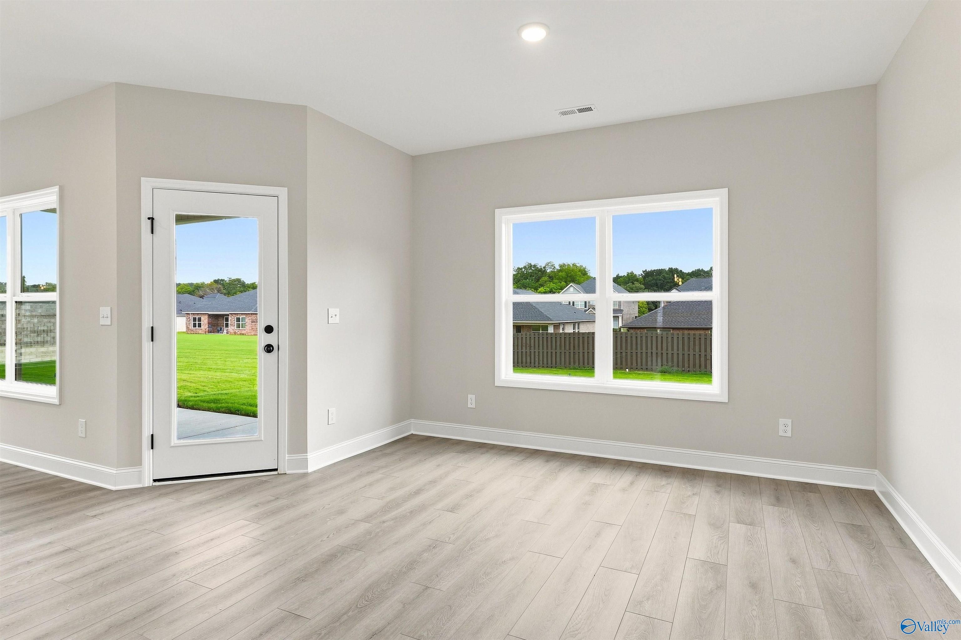 Bright dining area with luxury vinyl plank flooring, glass back door, and backyard views in Davidson Homes Franklin C, Athens, AL