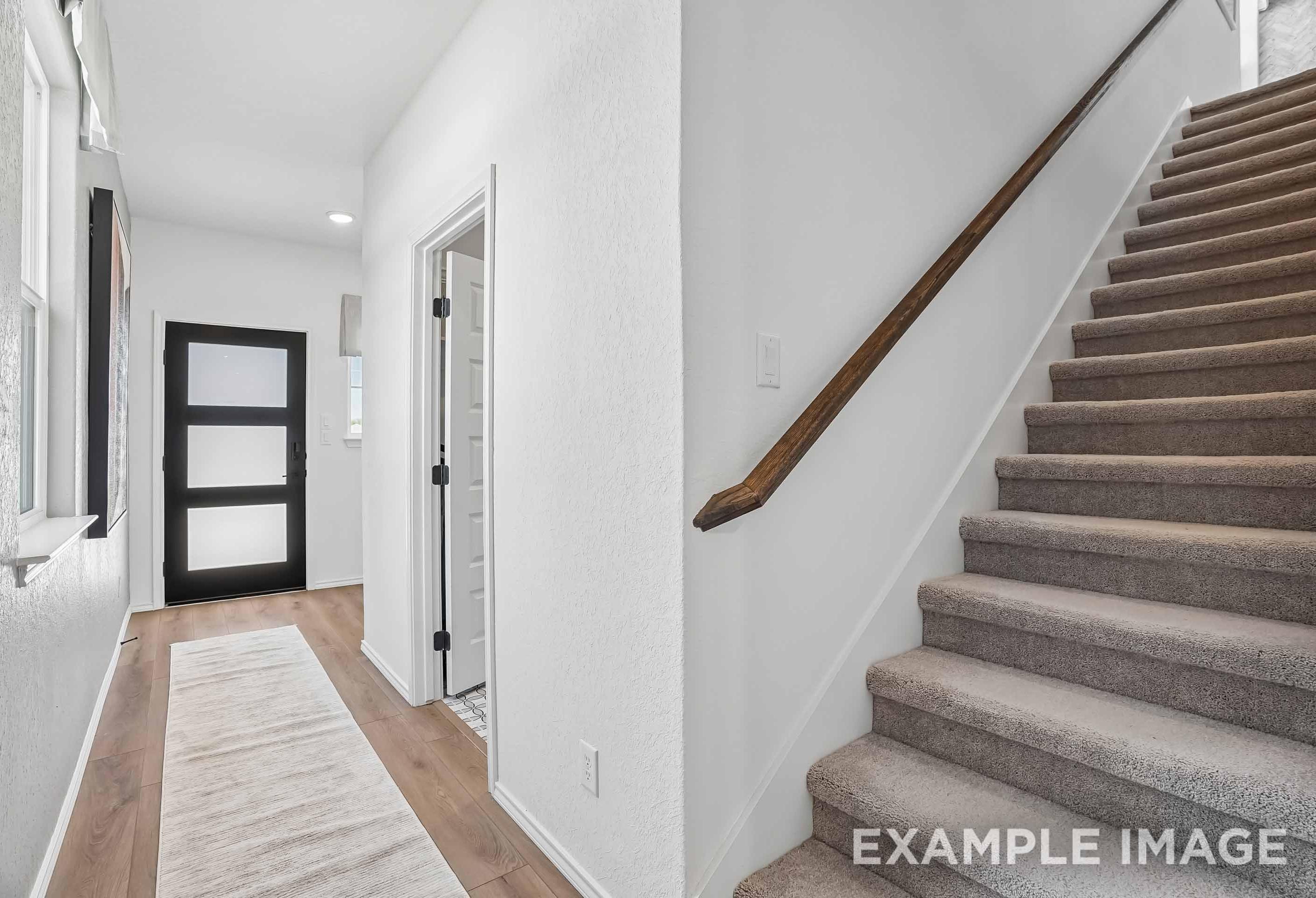 Modern foyer entry and carpeted staircase in The Pinecrest B floor plan by Davidson Homes.