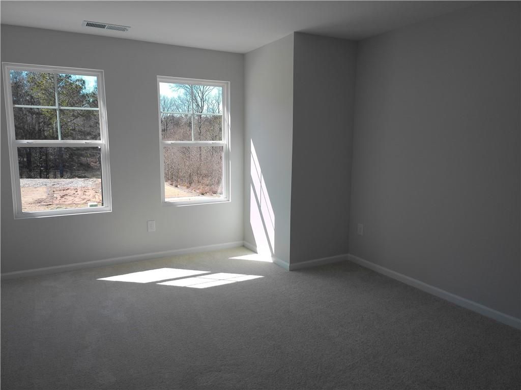 Bright empty bedroom with large windows and sunlight streaming in, Davidson Homes The Marion C, Winder, Georgia