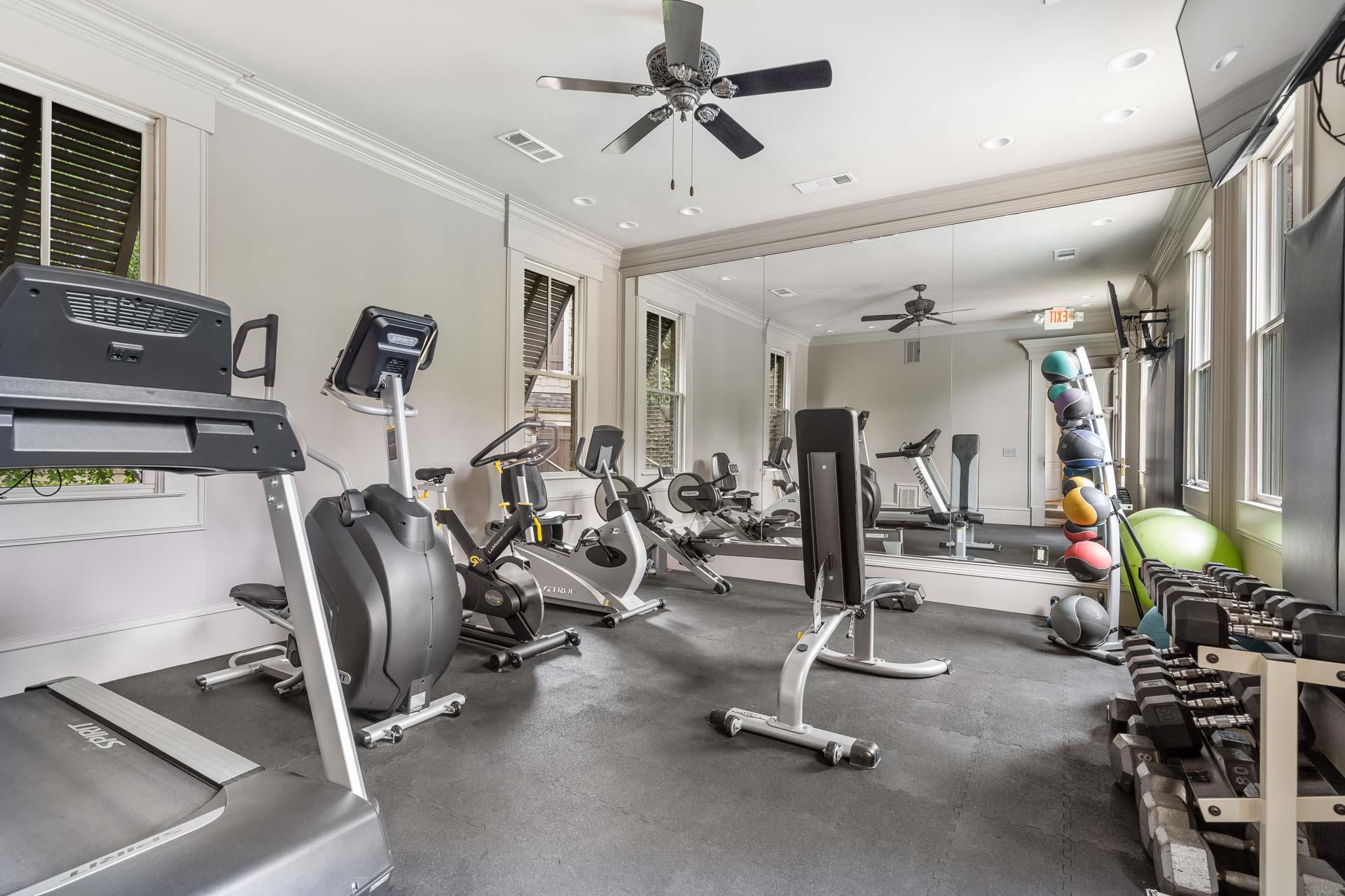 Spacious fitness center at The Village at Towne Lake in Woodstock GA with treadmills bikes weights mirrors and rubber flooring