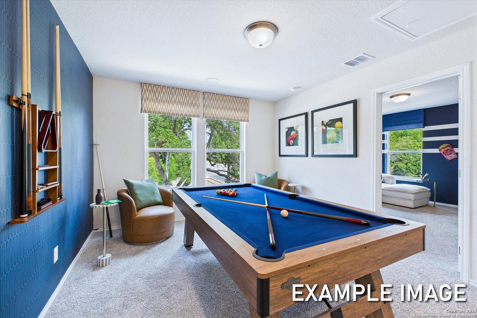 Cozy game room featuring blue pool table, cue rack, and plush seating with window views in Davidson Homes The Gillian C, San Antonio