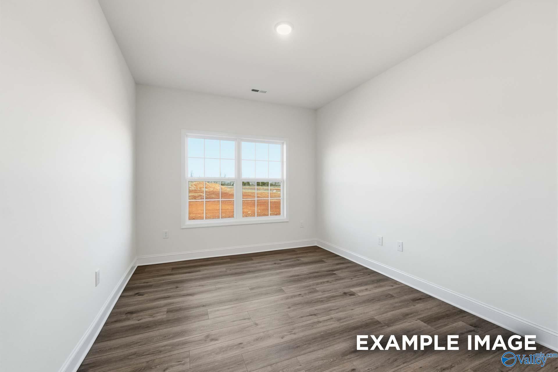 Bright, spacious bedroom with wood-look flooring in The Valencia floor plan by Davidson Homes in Briercreek, Meridianville.