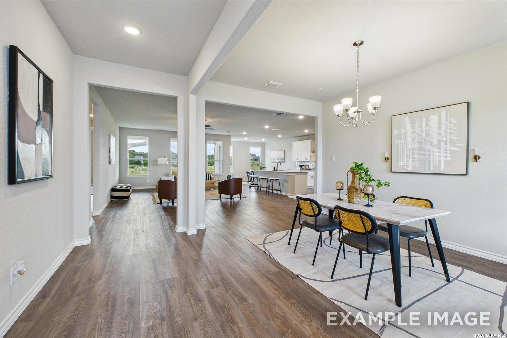 Open-concept dining and living area with modern decor in The Foster F floor plan at Potranco Oaks, Castroville, Texas.