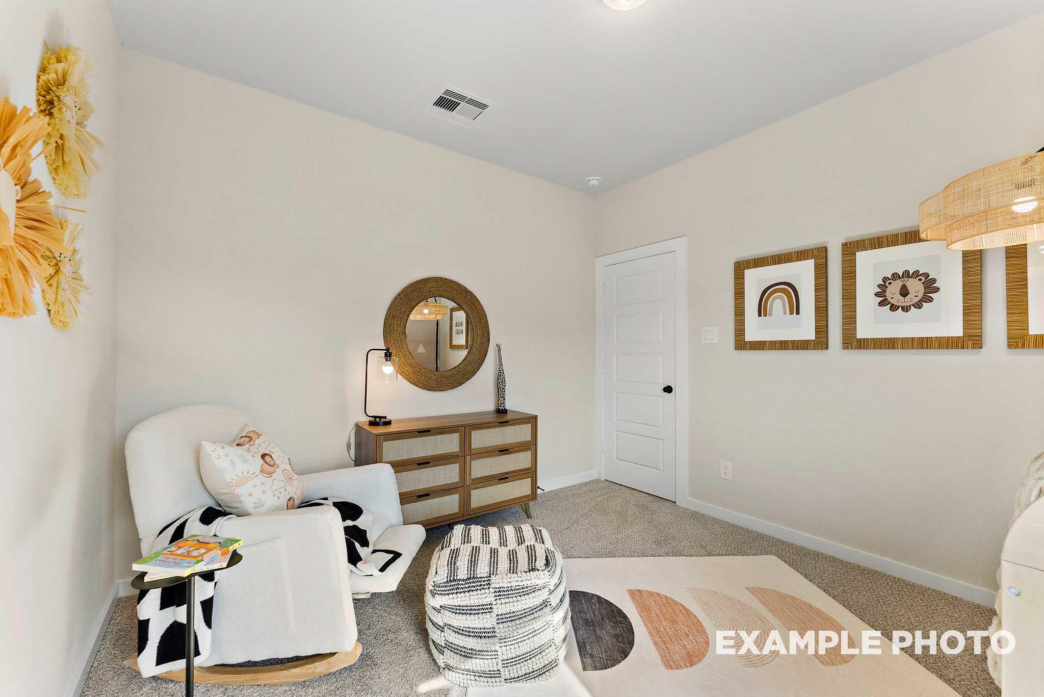 Boho-style nursery with white rocking chair and wicker decor in The Everett E floor plan at Sundance Cove, Crosby, Texas.