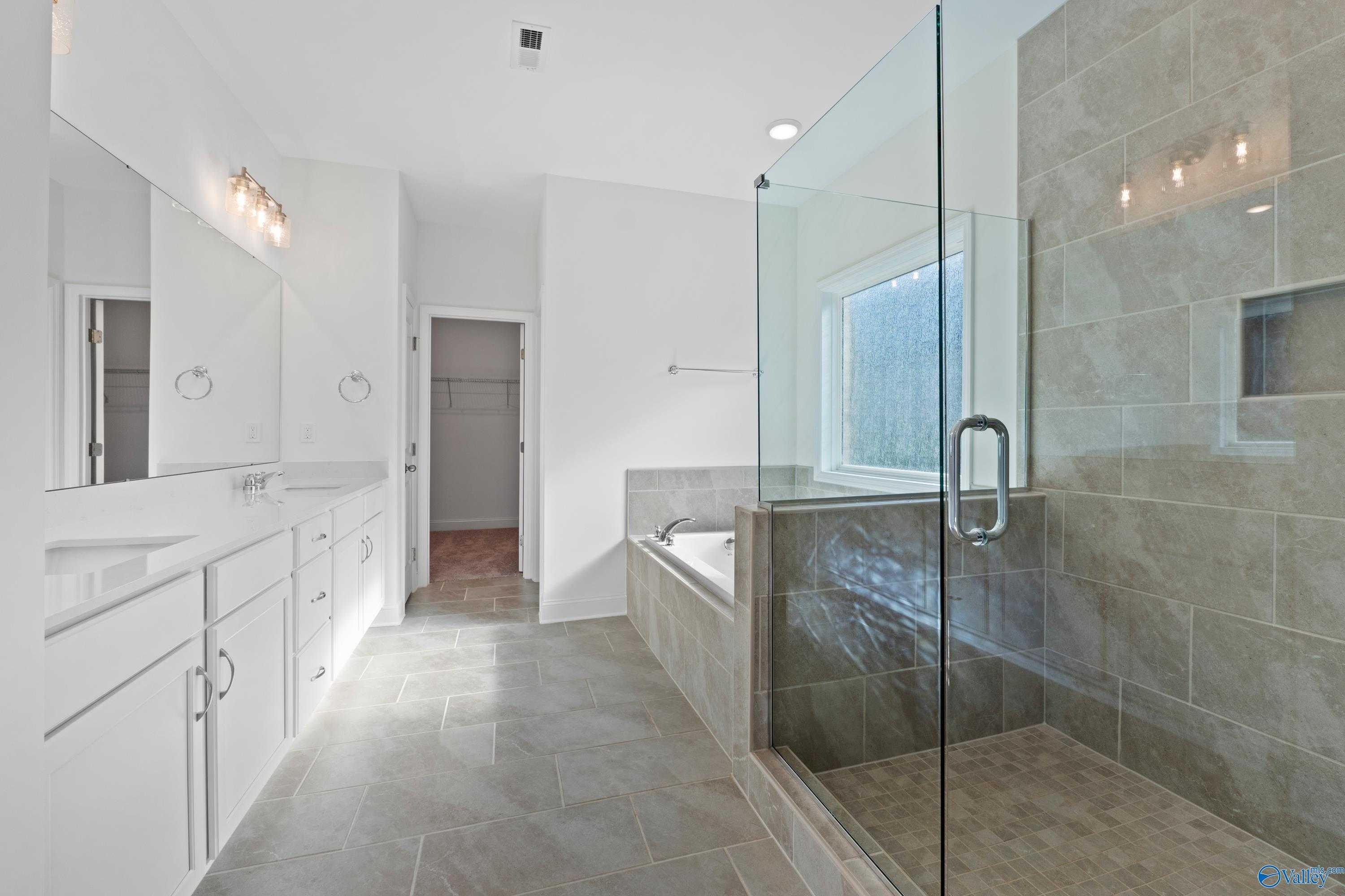 Luxurious master bathroom featuring double vanity, freestanding tub, and glass walk-in shower in Davidson Homes The Oxford, Harvest, Alabama