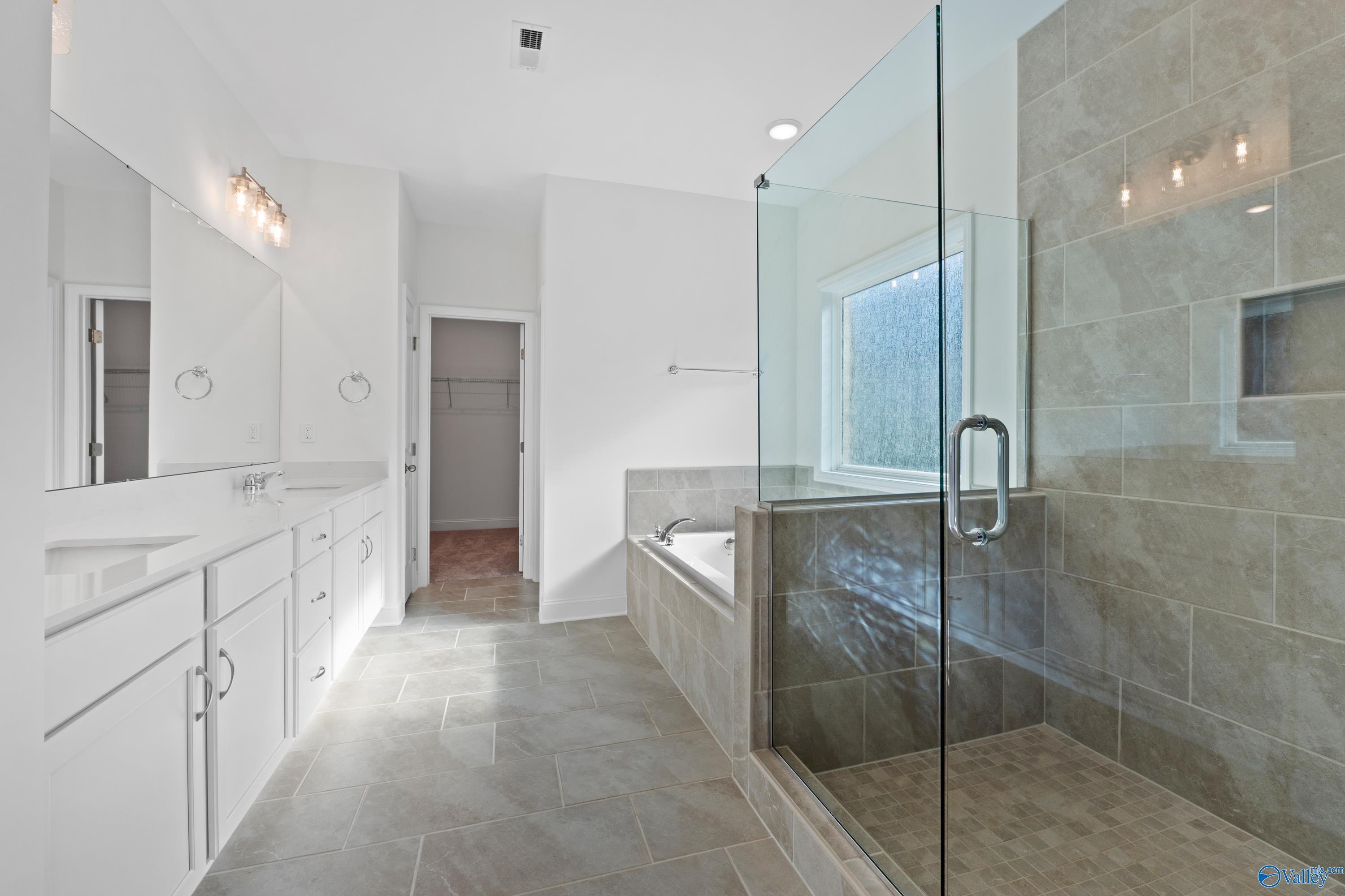 Luxurious master bathroom featuring double vanity, freestanding tub, and glass walk-in shower in Davidson Homes The Oxford, Harvest, Alabama