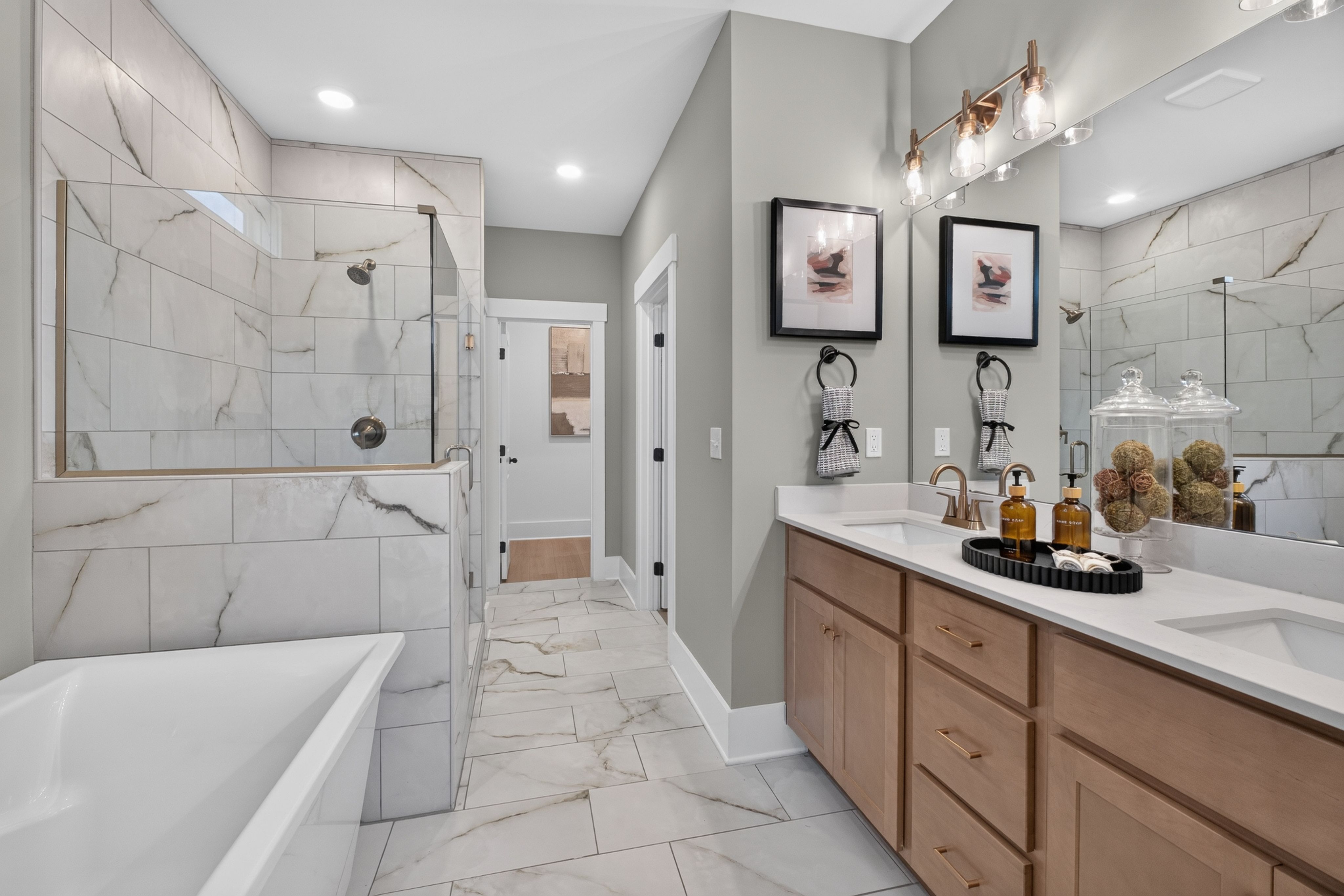 Owner's bathroom at Evergreen Mill in Madison, Alabama with marble tile walk-in shower, freestanding tub, and dual vanity