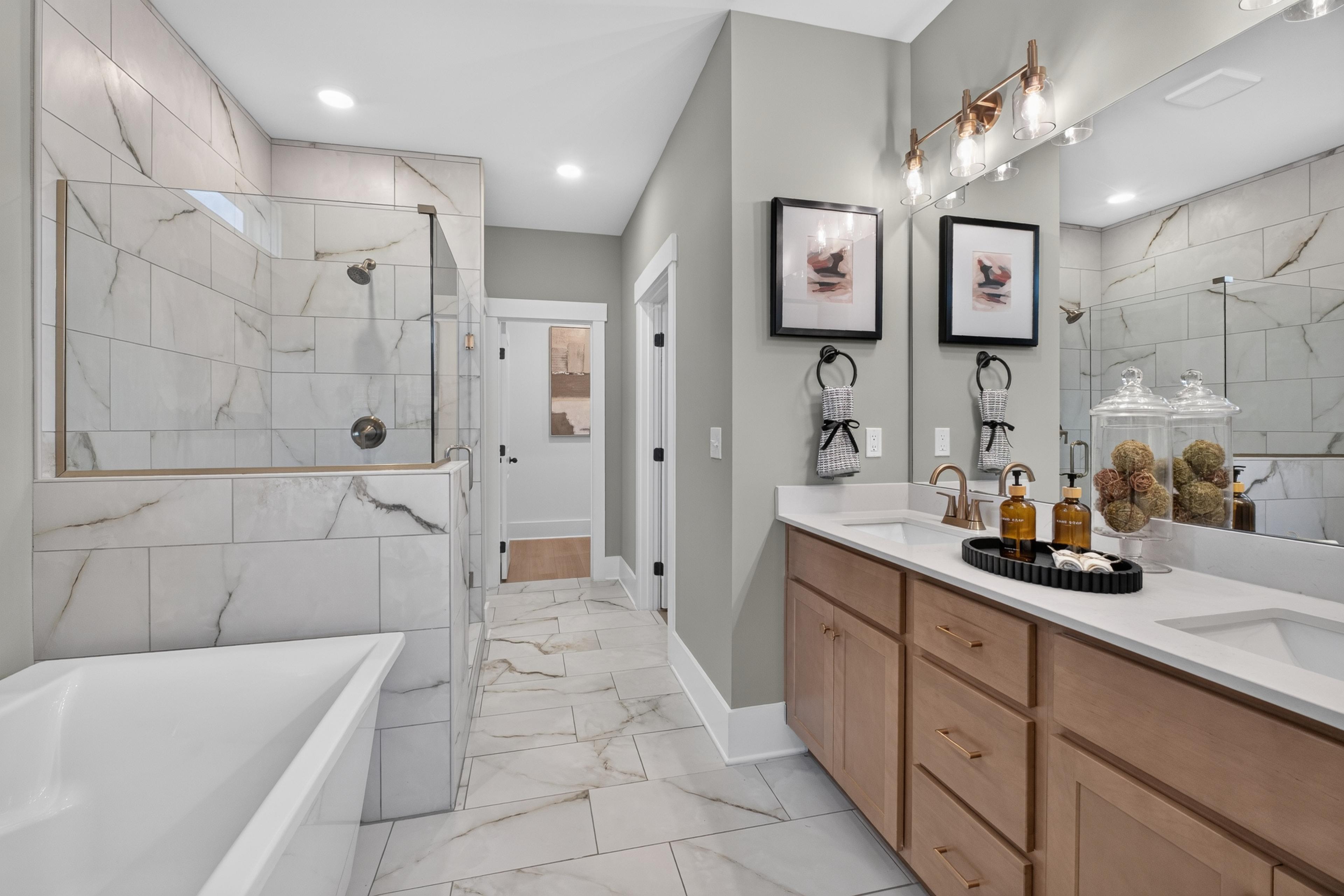 Owner's bathroom at Evergreen Mill in Madison, Alabama with marble tile walk-in shower, freestanding tub, and dual vanity