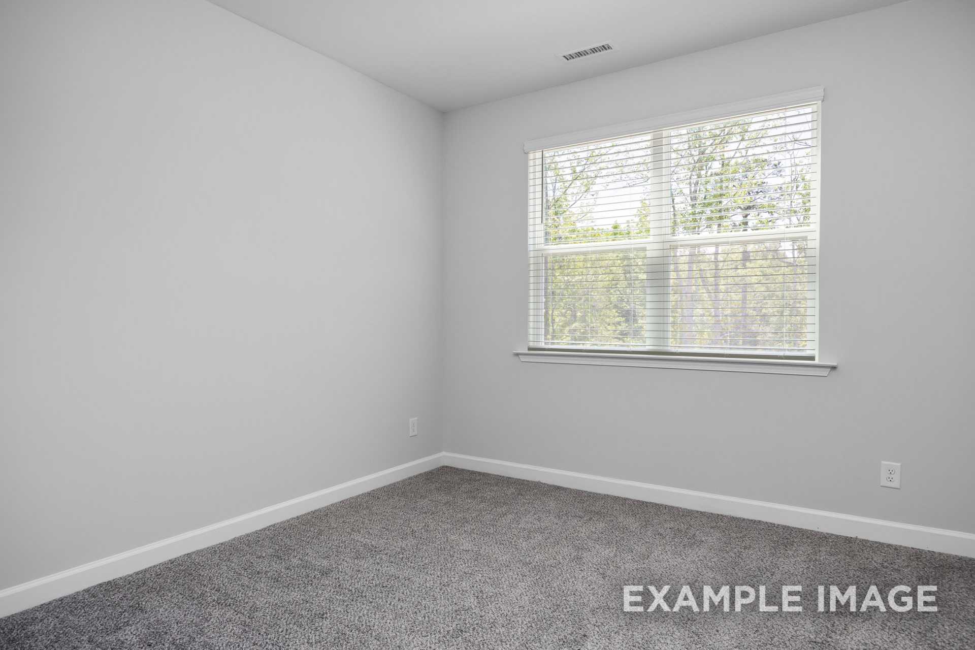 Spacious secondary bedroom in The Preston B with gray walls, carpet flooring, and large windows with blinds