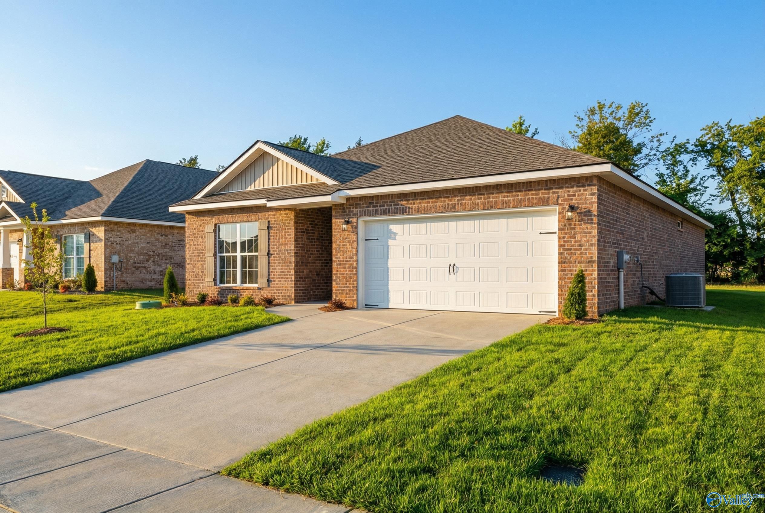 Modern brick 1-story home with 2-car garage, driveway, and lush green lawn in Lynn Meadows, Meridianville, Alabama by Davidson Homes The Franklin