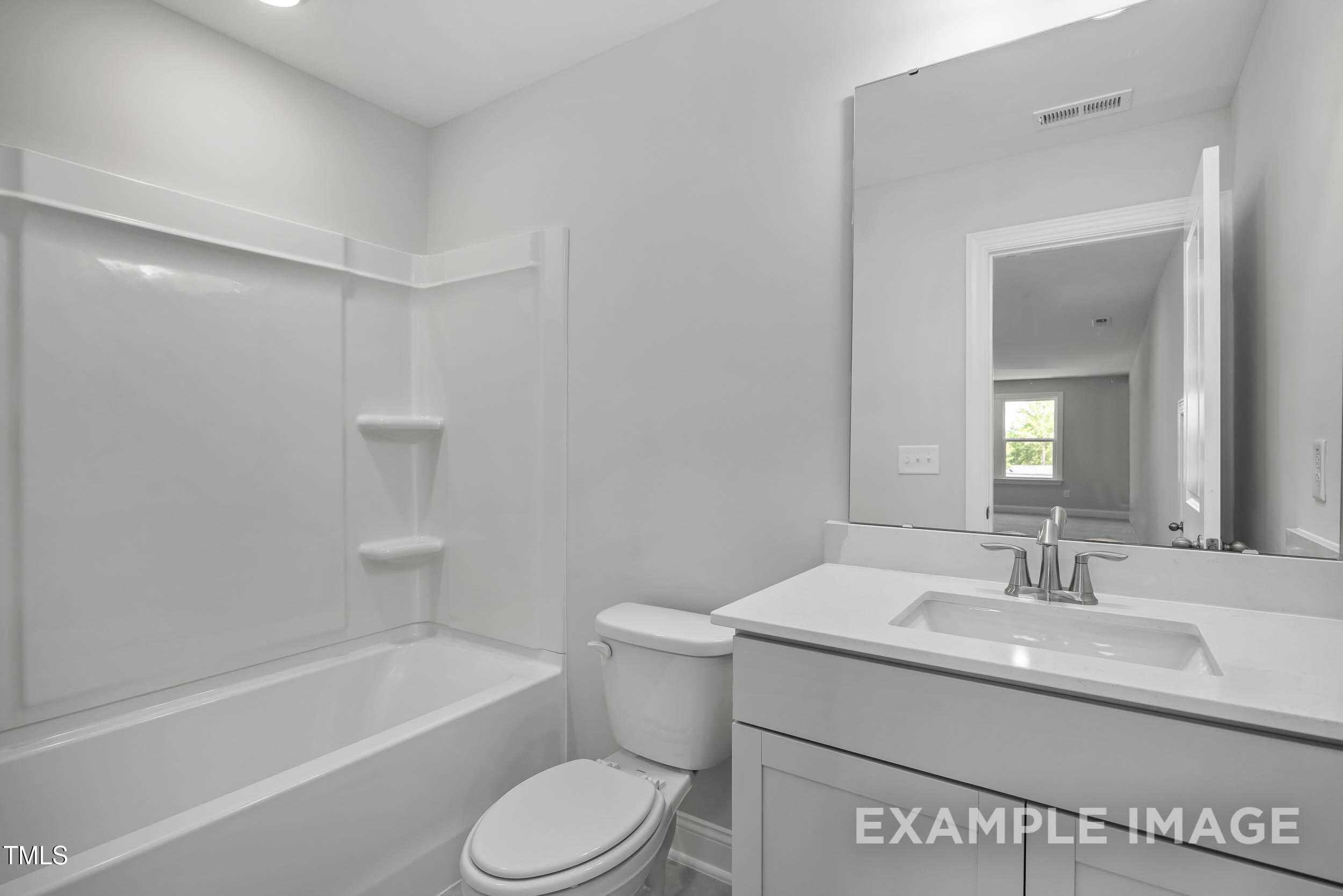 Modern bathroom with glass shower enclosure, soaking tub, and white vanity in Davidson Homes The Beech B, Laneridge Estates, Raleigh, NC