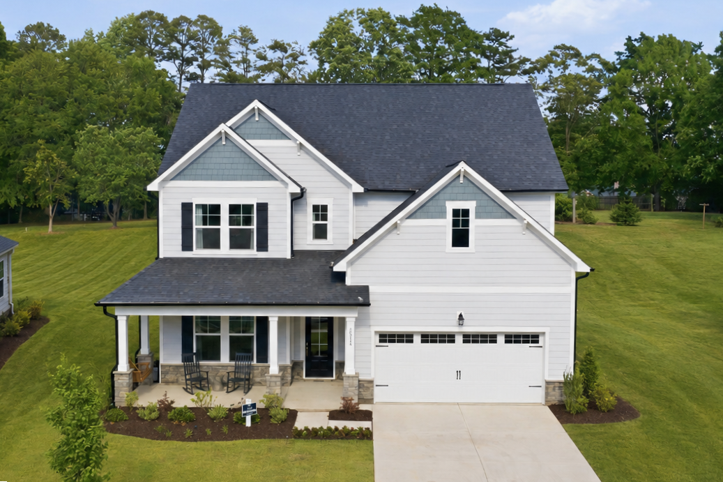 Modern craftsman-style home exterior at Enclave at Belmont in Belmont NC with covered porch, two-car garage, and lush landscaping