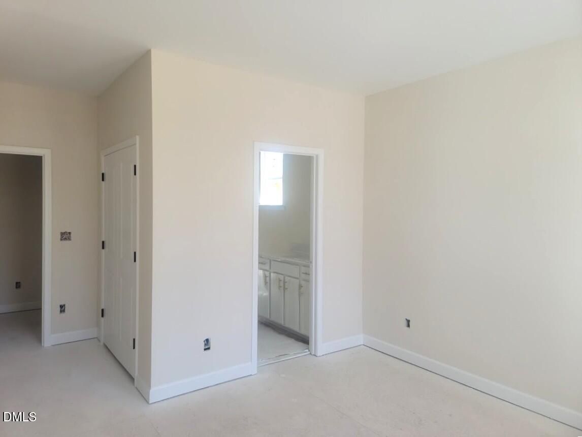Bright master bathroom entry with white vanity, bi-fold closet doors in 4-bed Davidson Homes Cypress B II, Angier NC