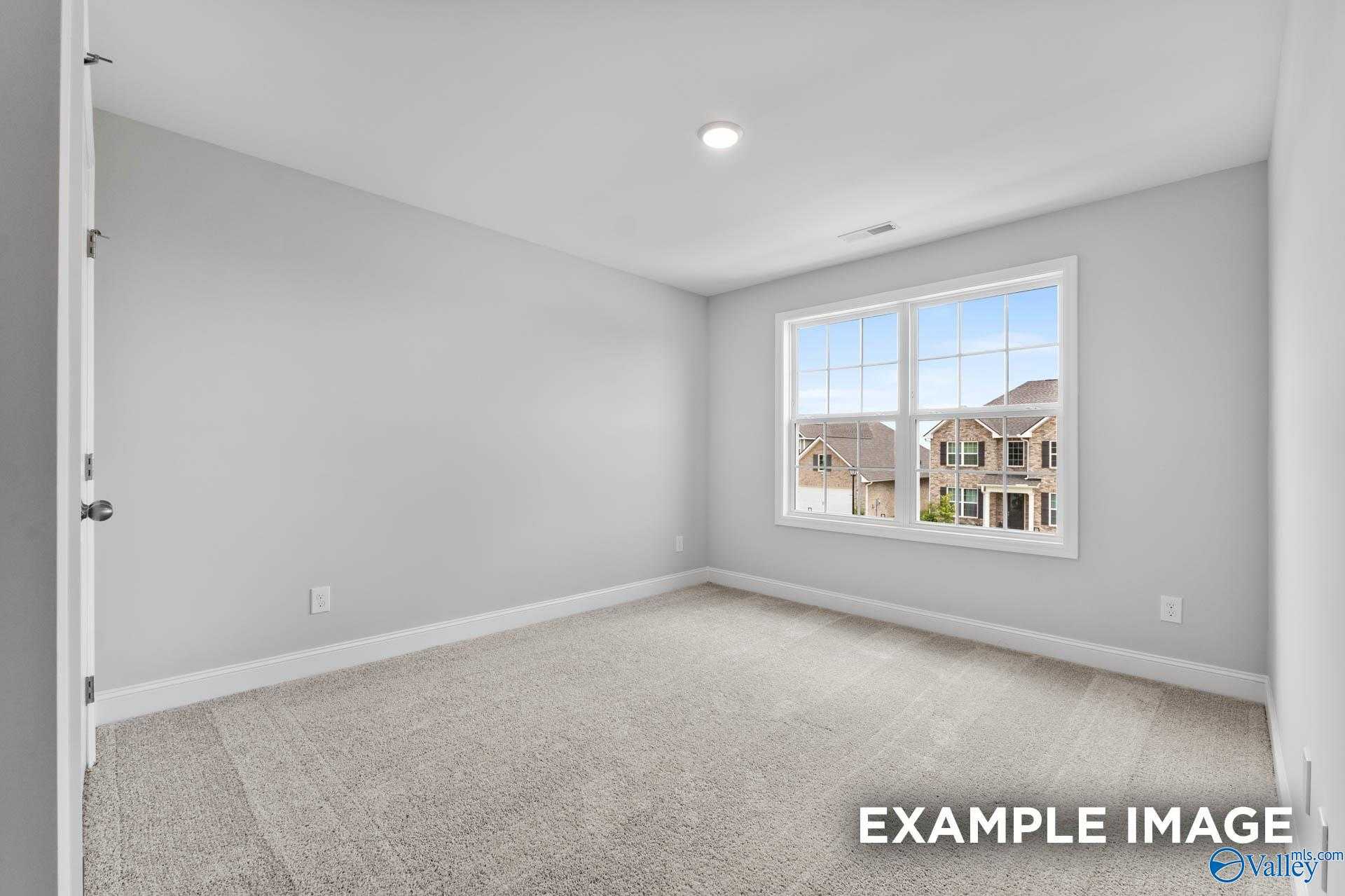 Bright secondary bedroom with gray walls, beige carpet, and neighborhood view window in Davidson Homes The Madison A, Harvest, Alabama