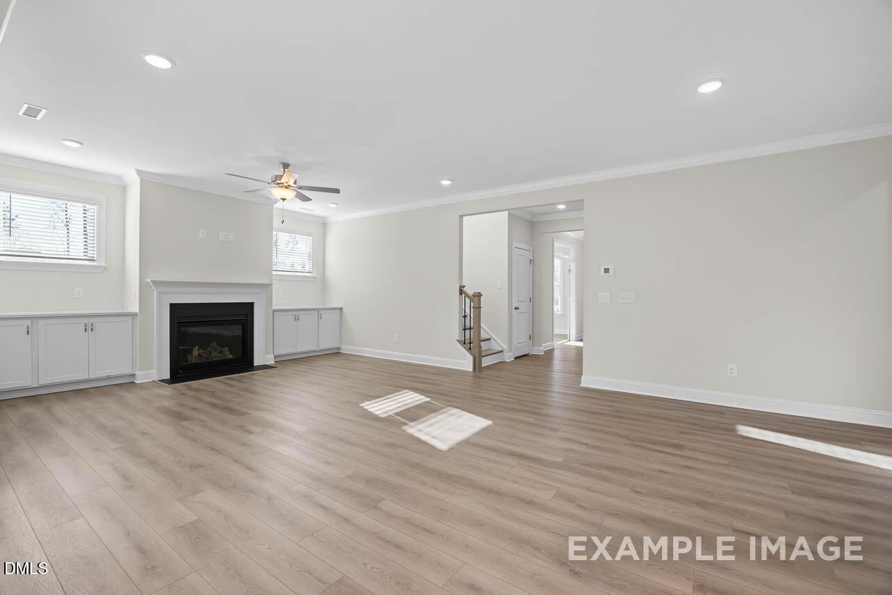 Spacious living room with fireplace and light wood floors in The Aspen C floor plan by Davidson Homes in Ashland, Apex.