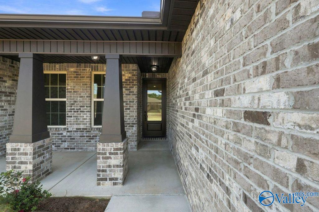 Covered brick front porch and entryway of The Rockford floor plan by Davidson Homes in Cain Park, Hartselle, Alabama.
