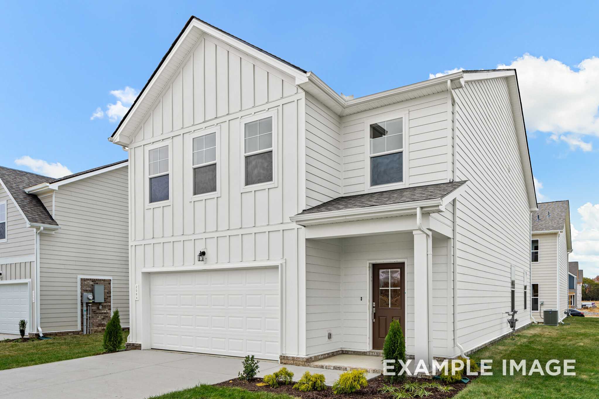 Two-story Grayson A elevation featuring white board-and-batten siding, covered front porch, and two-car garage