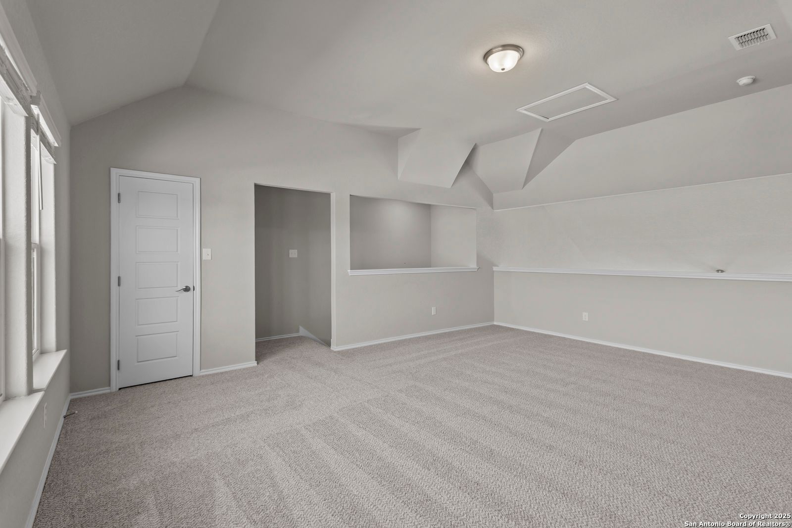 Spacious bedroom with vaulted ceiling, built-in shelves, and carpet in Davidson Homes The Collin B, Seguin Texas