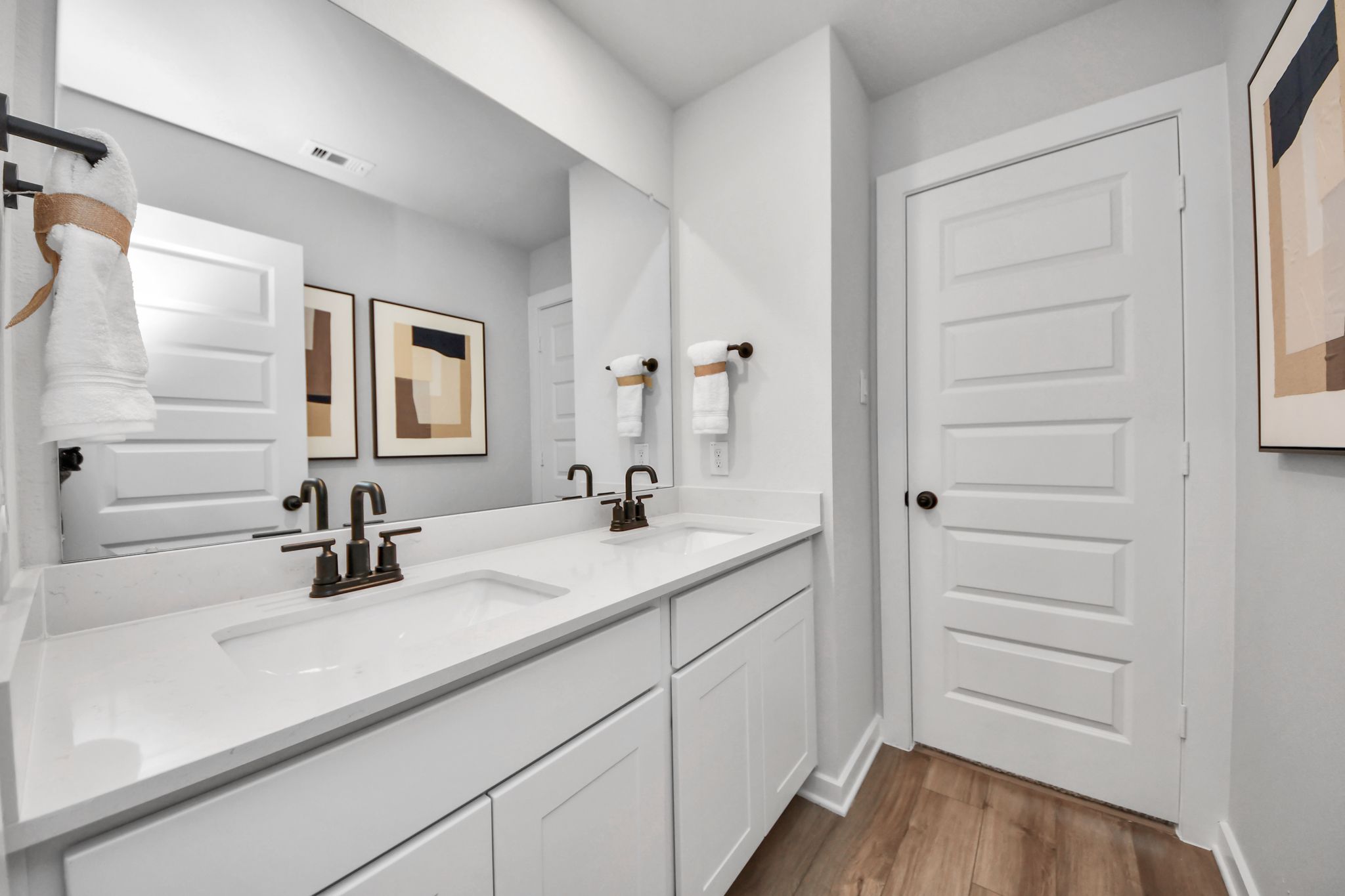 Modern double vanity bathroom at Robins Landing in Houston, TX by Davidson Homes with white quartz countertops.
