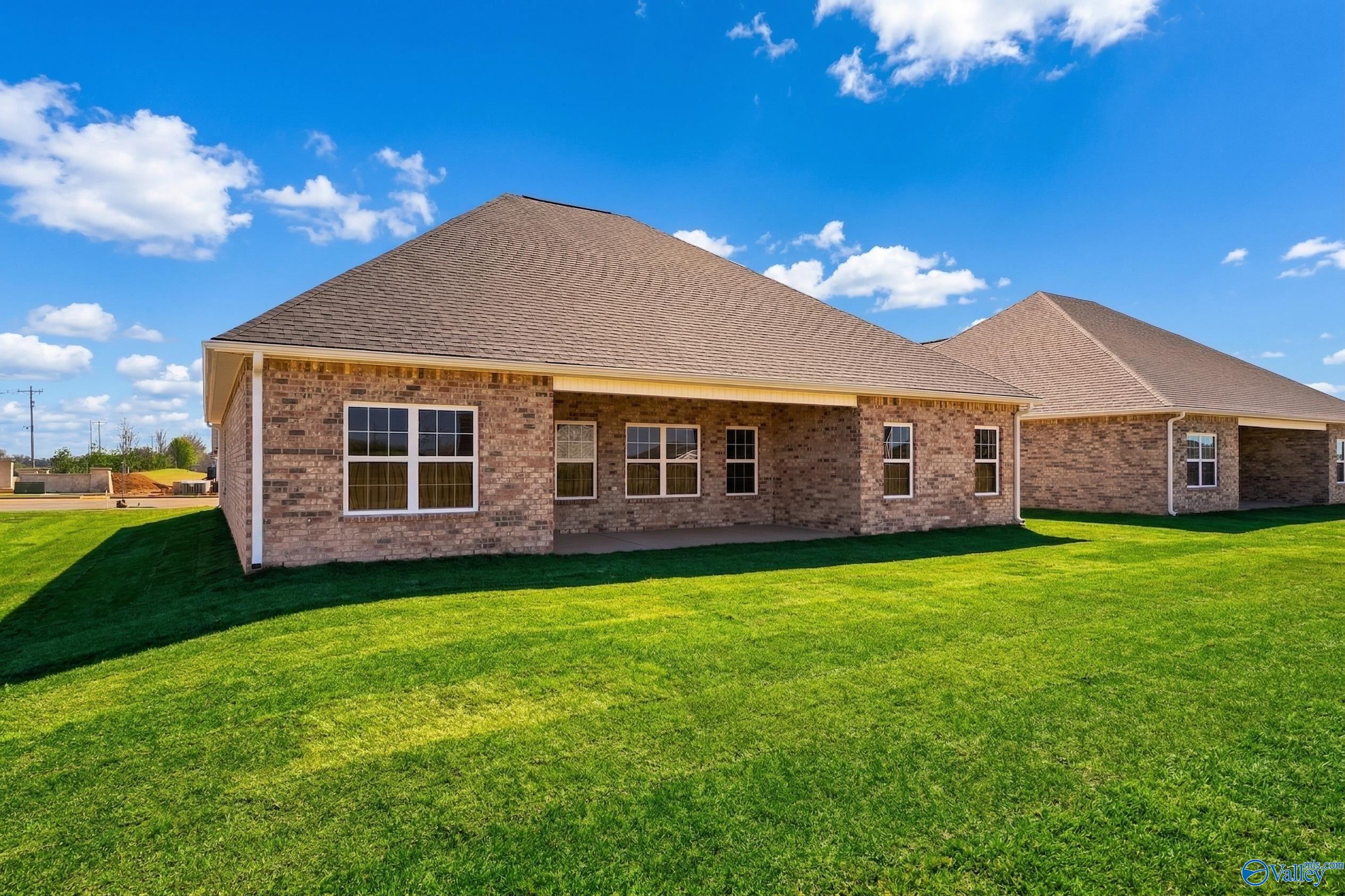 Single-story brick home with shingled roof, covered porch, lush green lawn in Creekside, Harvest, Alabama - Davidson Homes Rockford