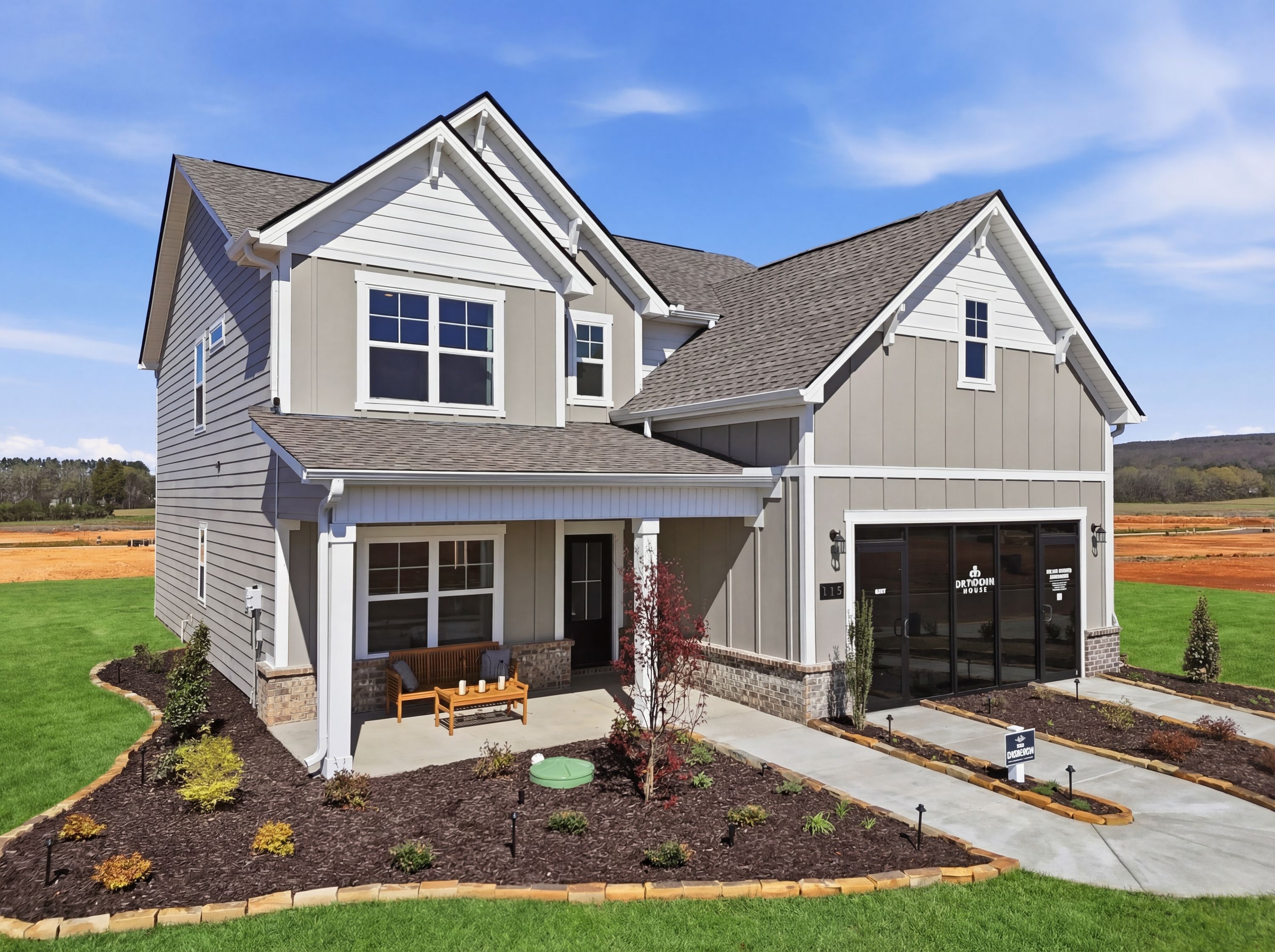Contemporary craftsman-style home at Berry Cove in New Market, Alabama with covered porch, garage, and landscaped yard overlooking fields