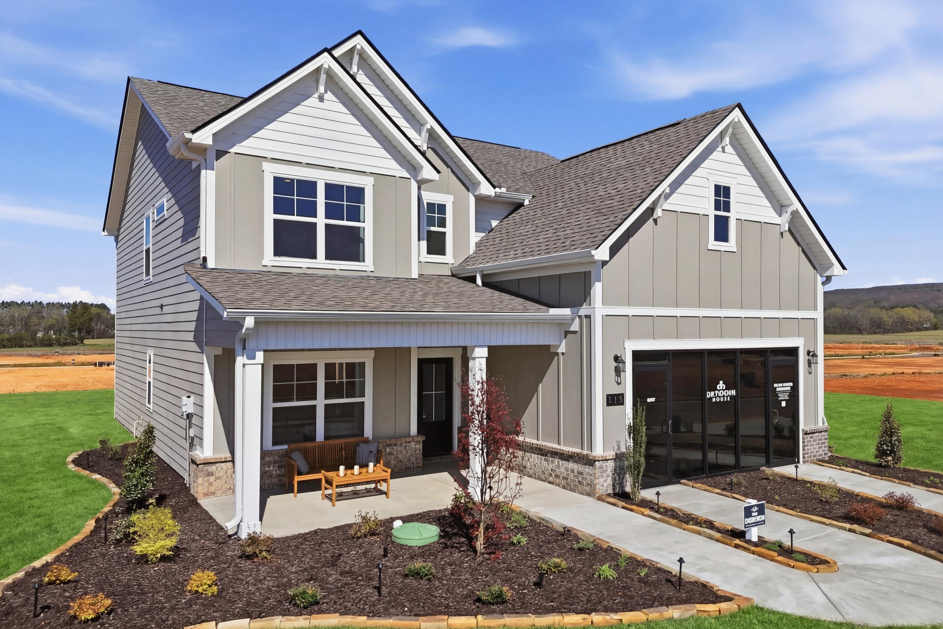Contemporary craftsman-style home at Berry Cove in New Market, Alabama with covered porch, garage, and landscaped yard overlooking fields