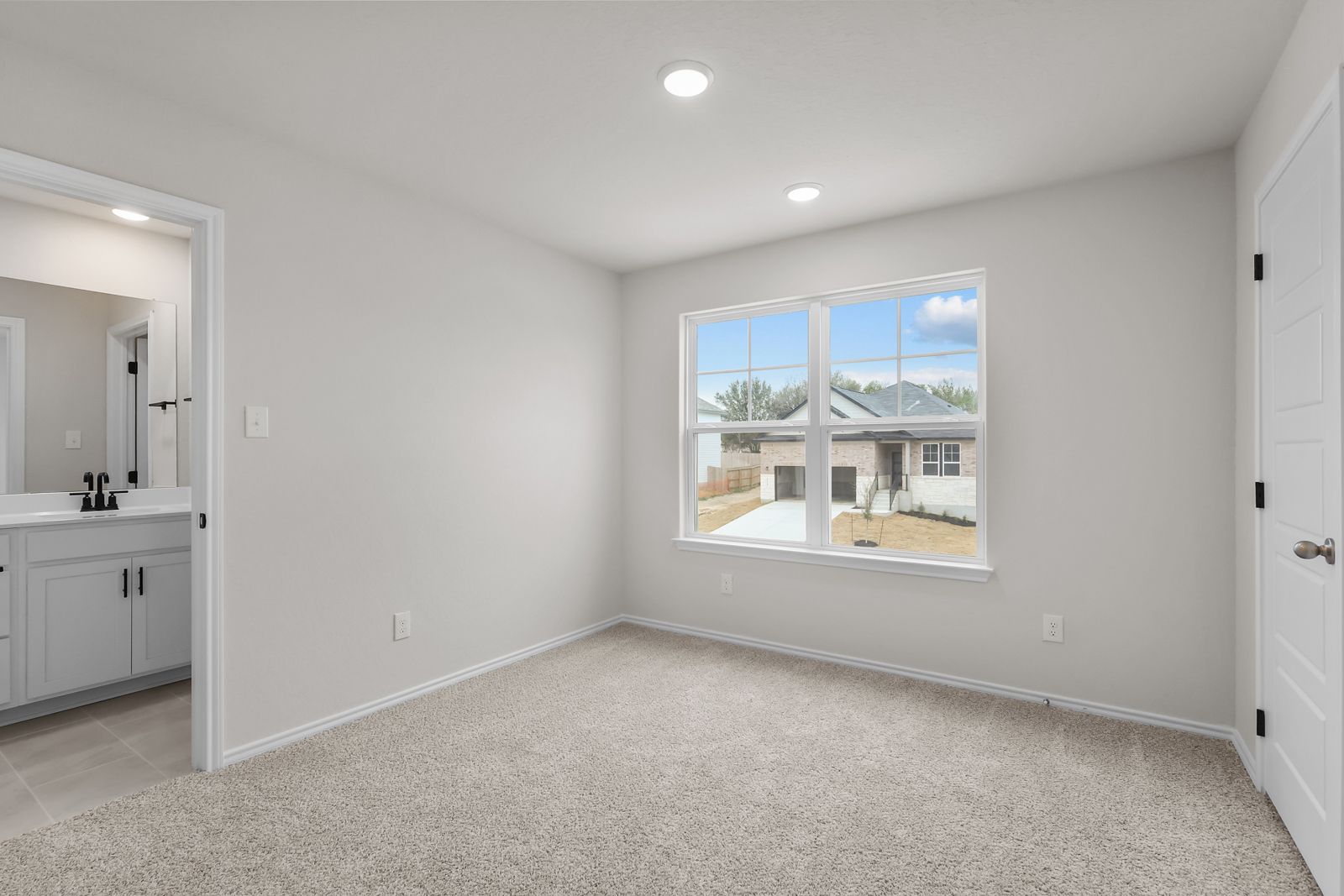 Spacious bedroom in The Sequoia C floor plan featuring plush carpeting, recessed lighting, and an attached ensuite bath.