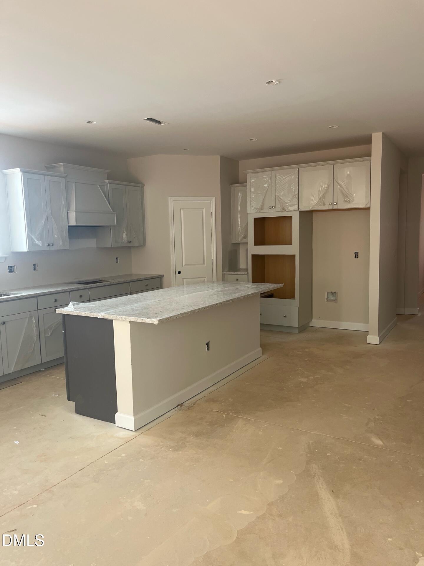 Modern white shaker kitchen with quartz island and open layout in Davidson Homes Ashport G, Wake Forest, NC