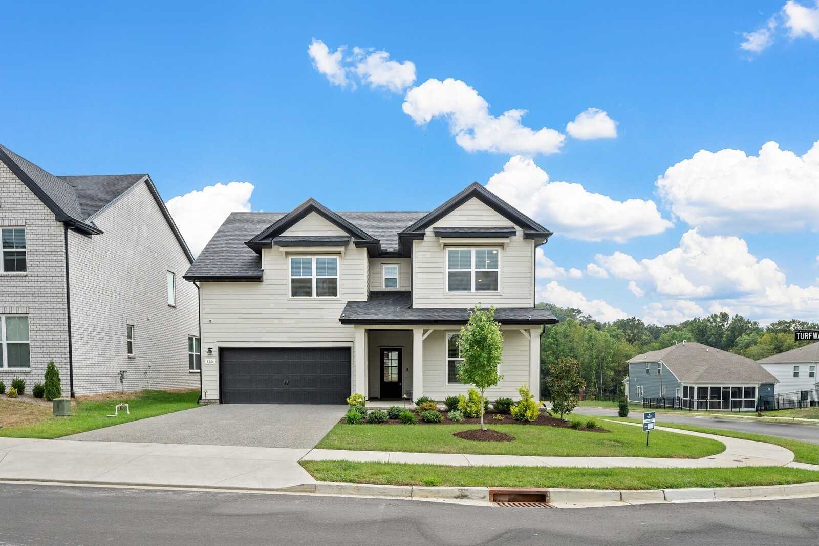 Modern two-story white home with black trim, two-car garage, and landscaped front yard in Carellton, Gallatin, Tennessee - Davidson Homes Ridgeport