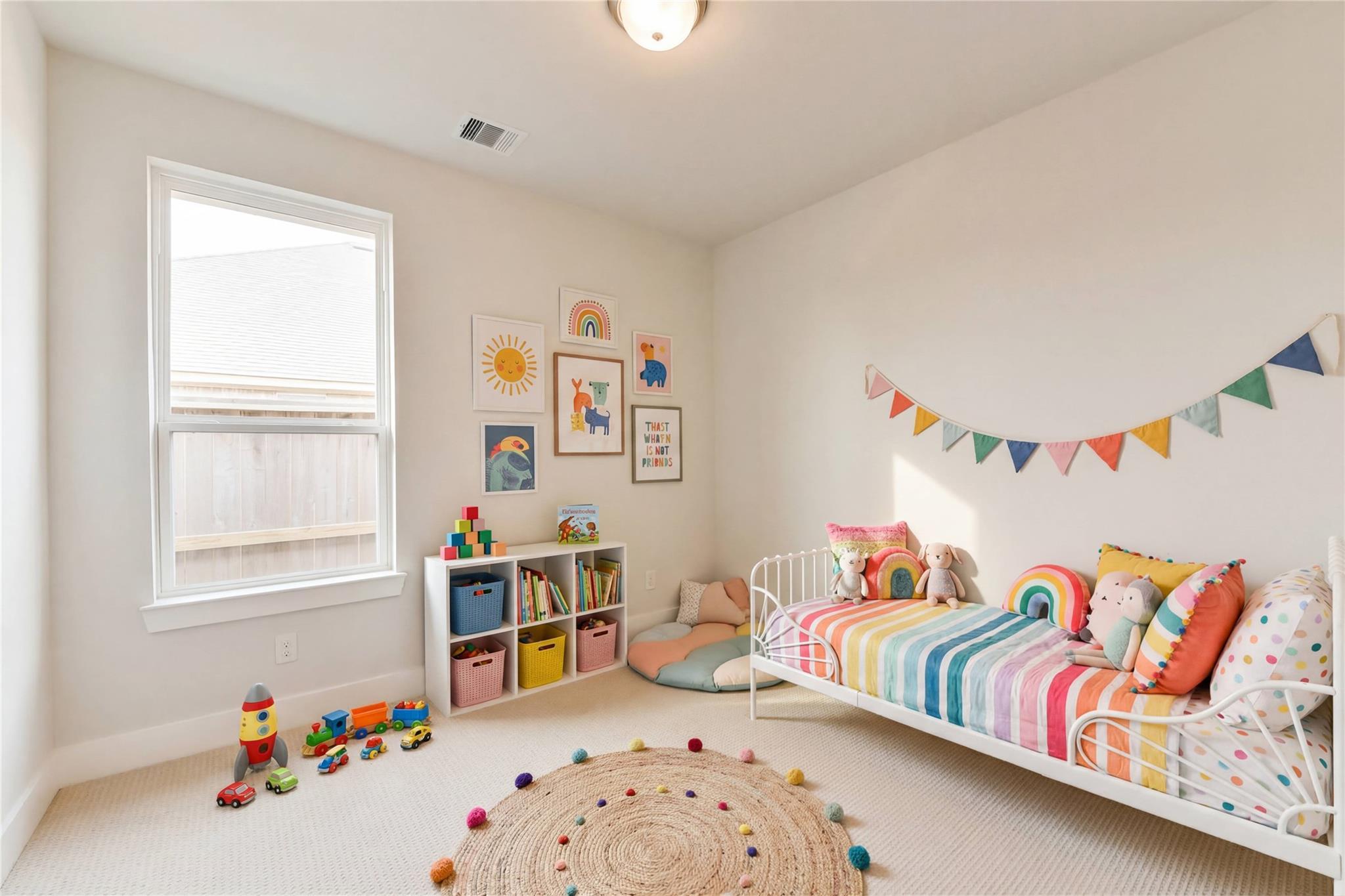 Colorful kids' bedroom with rainbow twin bed, toys, bookshelves and wall art in Davidson Homes The Edward A, Lago Mar, Texas City