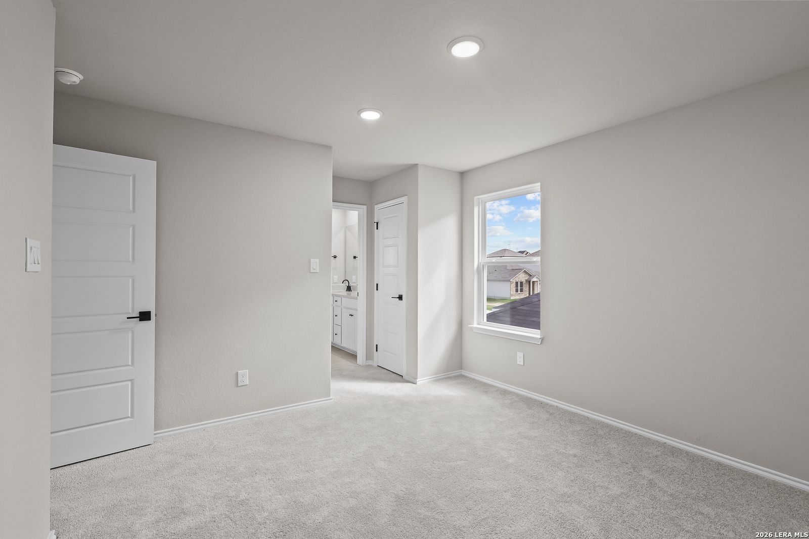 Bright bedroom with carpet, white doors, and window view in Davidson Homes The Sequoia C at Royal Crest, San Antonio, Texas