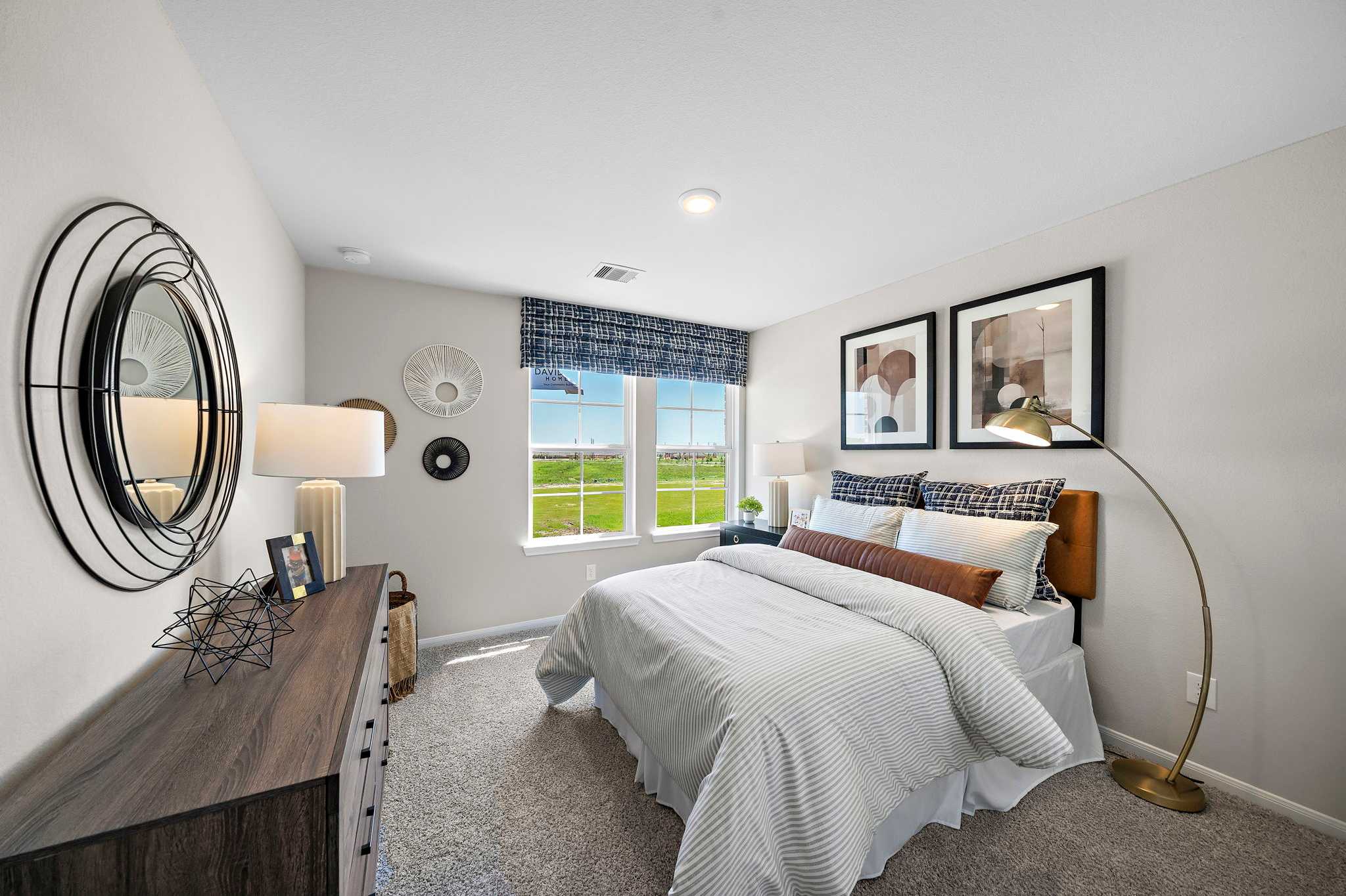 Cozy bedroom interior at Emberly in Beasley, Texas with queen bed, neutral walls, large windows overlooking fields and modern accents