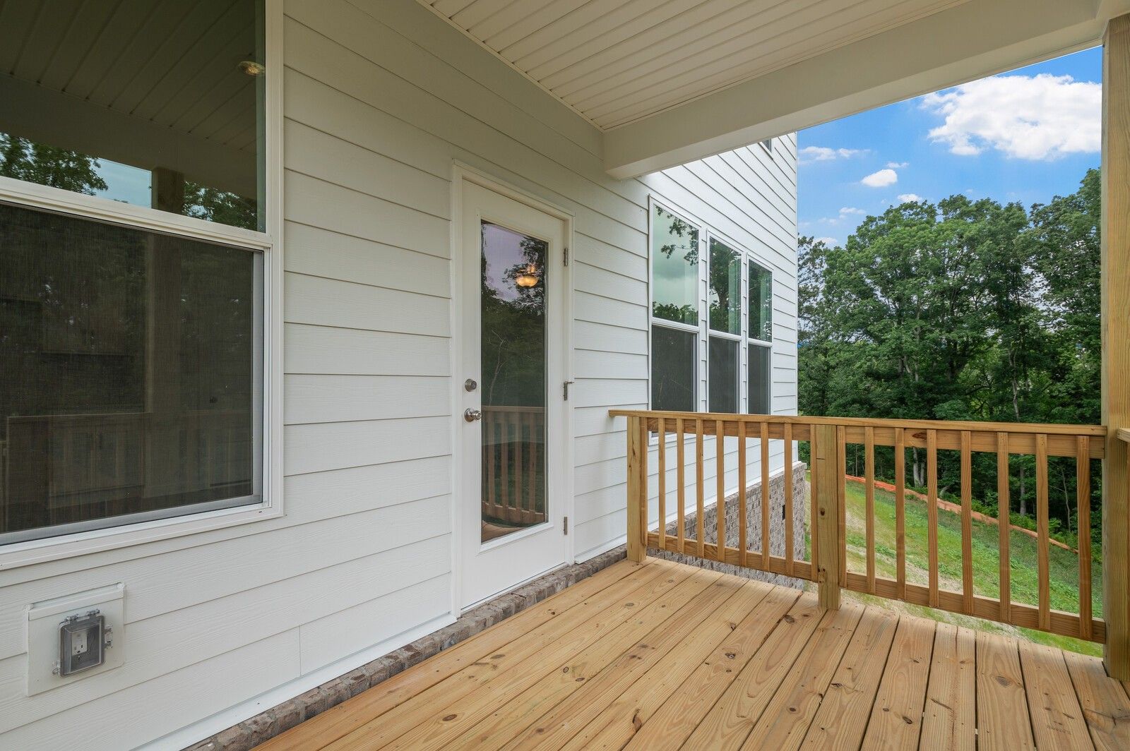 Covered wood deck overlooking lush forest at The Logan C floor plan home in Calista Farms, White House, Tennessee.