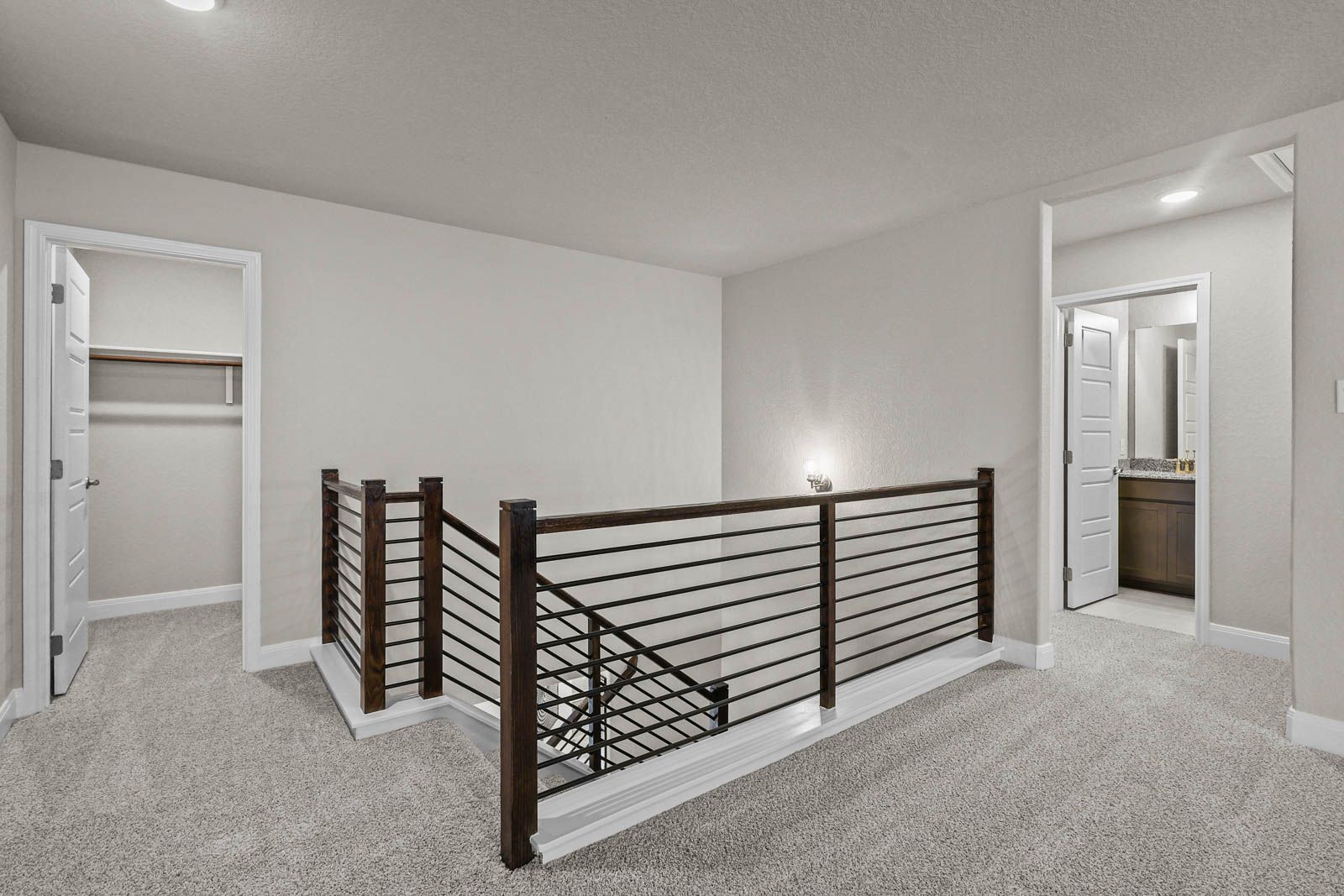 Second-floor landing in The Jennings G featuring modern metal railing, plush carpeting, and access to bedroom and bath.